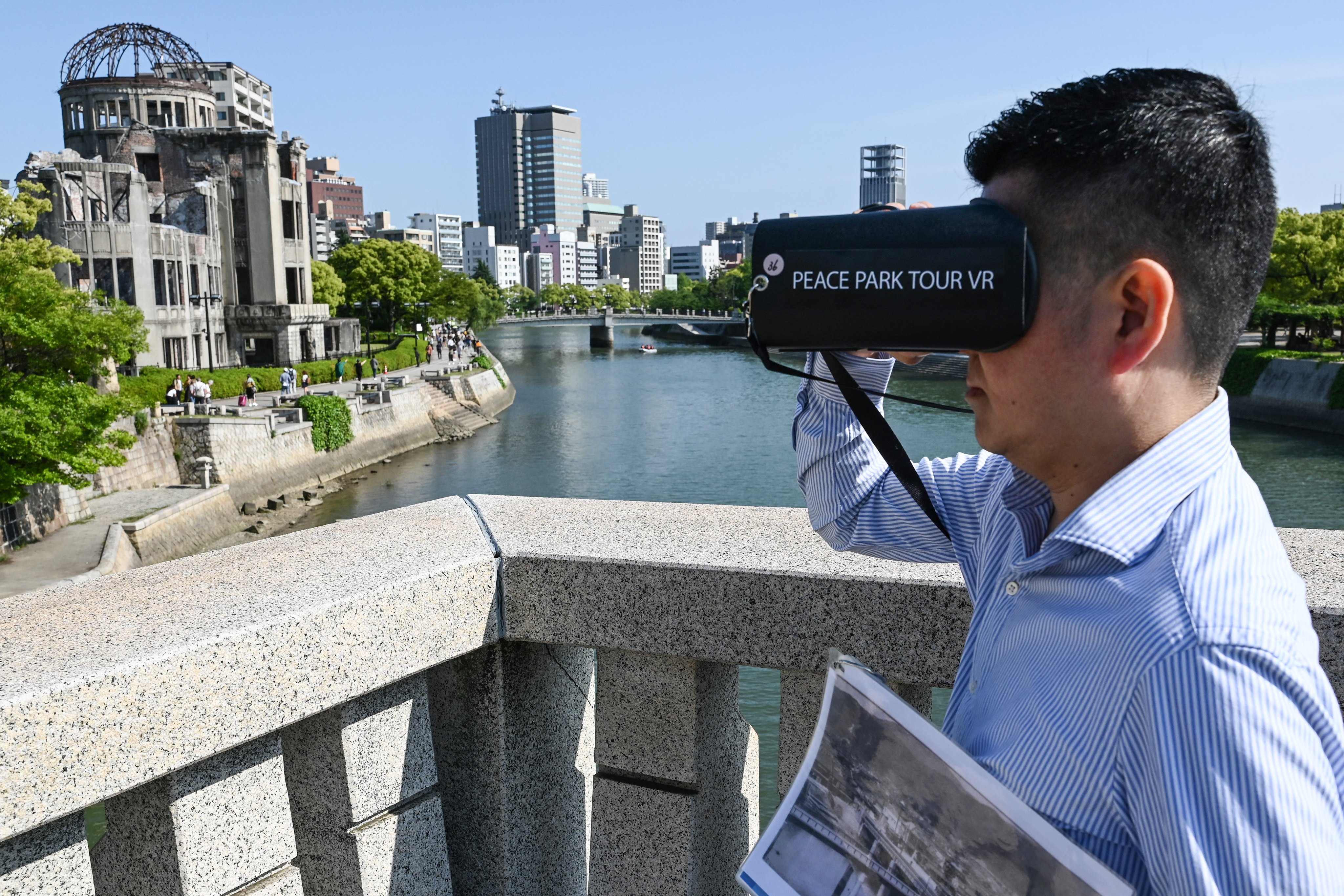 Tabimachi-Gate Hiroshima’s Hiroshi Yamaguchi uses his company’s VR headset on a tour of Hiroshima. Photo: AFP