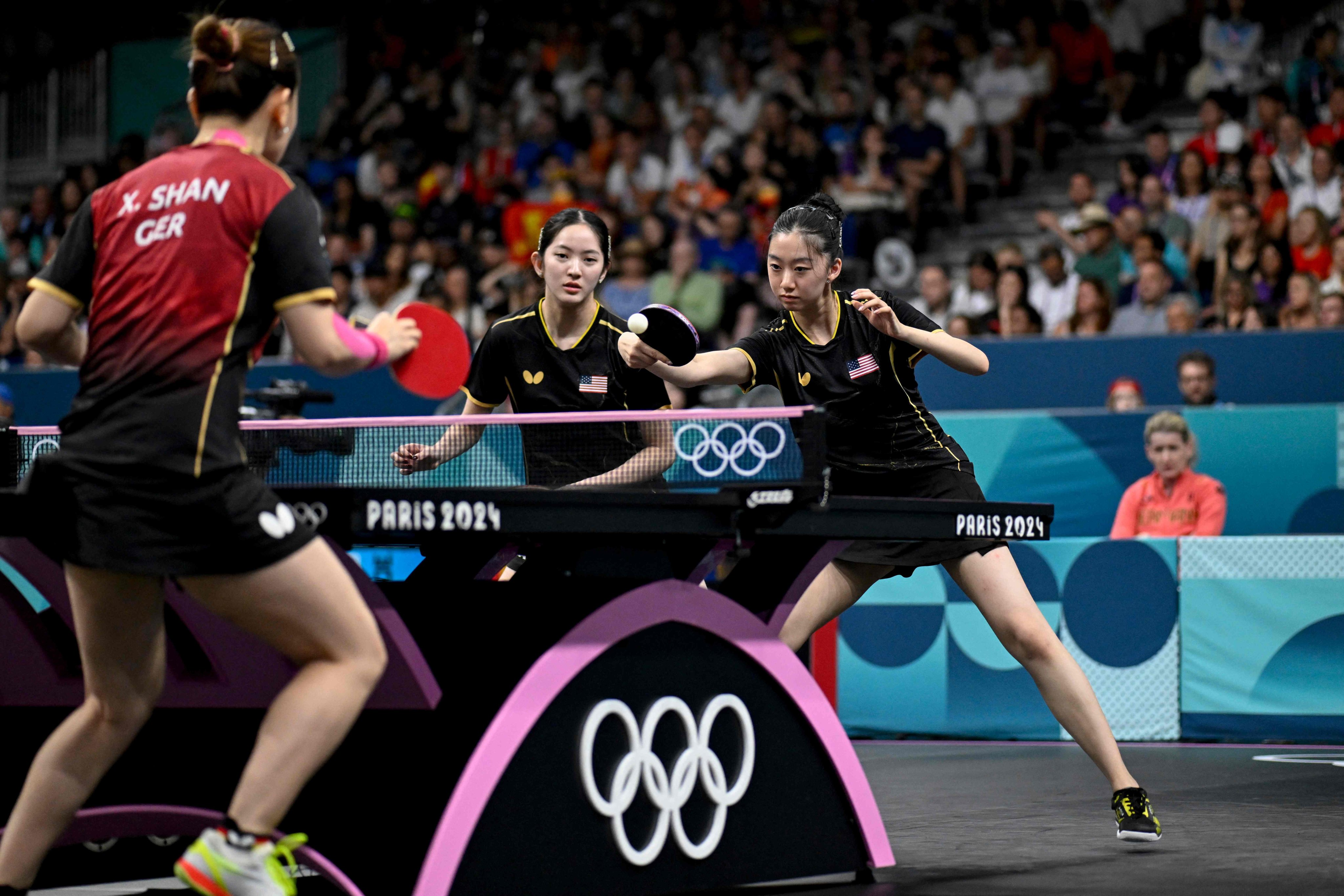 The USA’s Amy Wang (right) returns the ball to Germany’s Shan Xiaona as teammate Rachel Sung (centre) looks on in the Germans’ 3-2 win in their round of 16 match. Photo: AFP