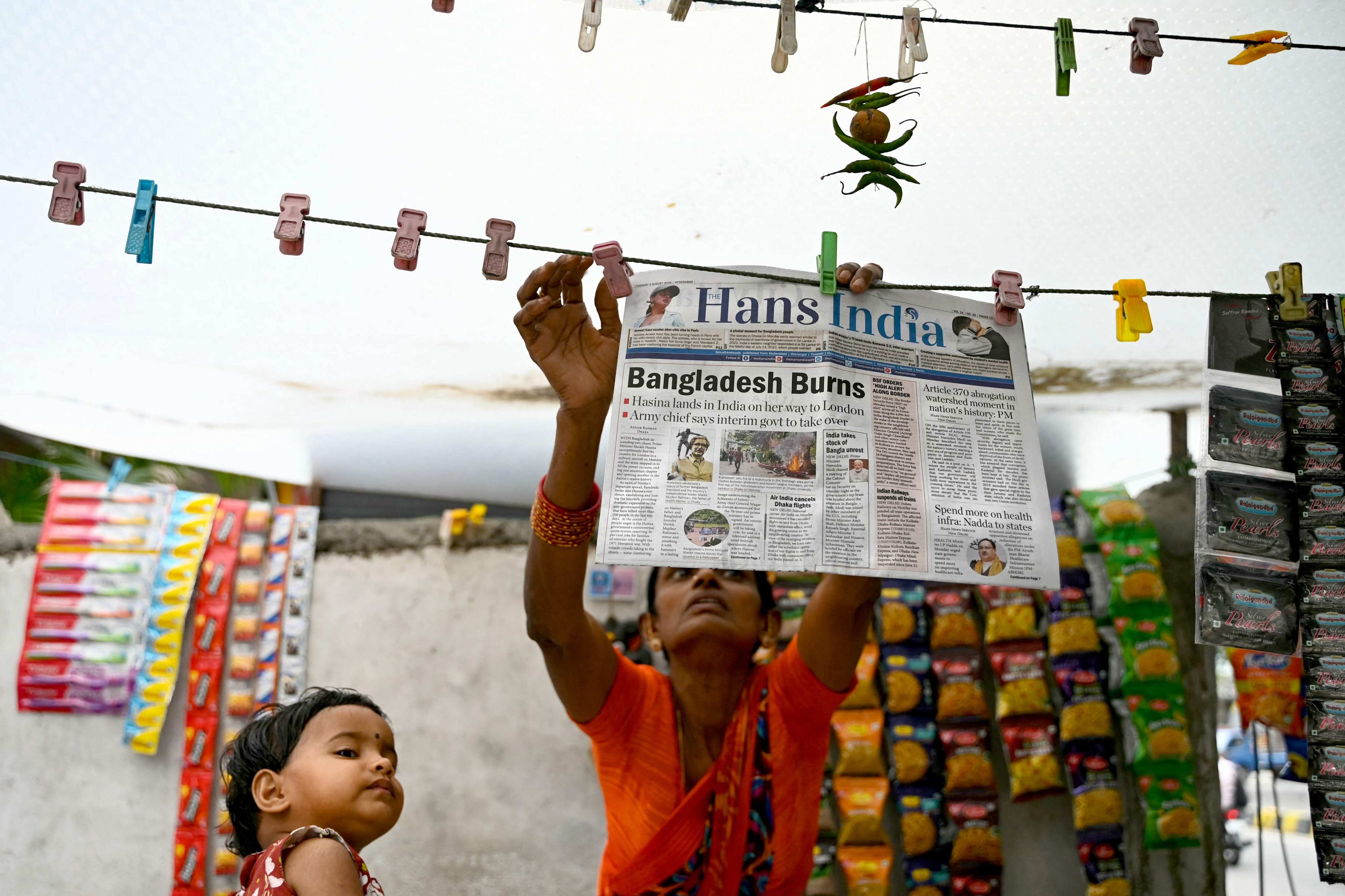 A vendor hangs a newspaper with the front page article reading “Bangladesh Burns” along a roadside in Hyderabad on Tuesday, a day after Bangladesh’s Prime Minister Sheikh Hasina was ousted by anti-government protestors. Photo: AFP