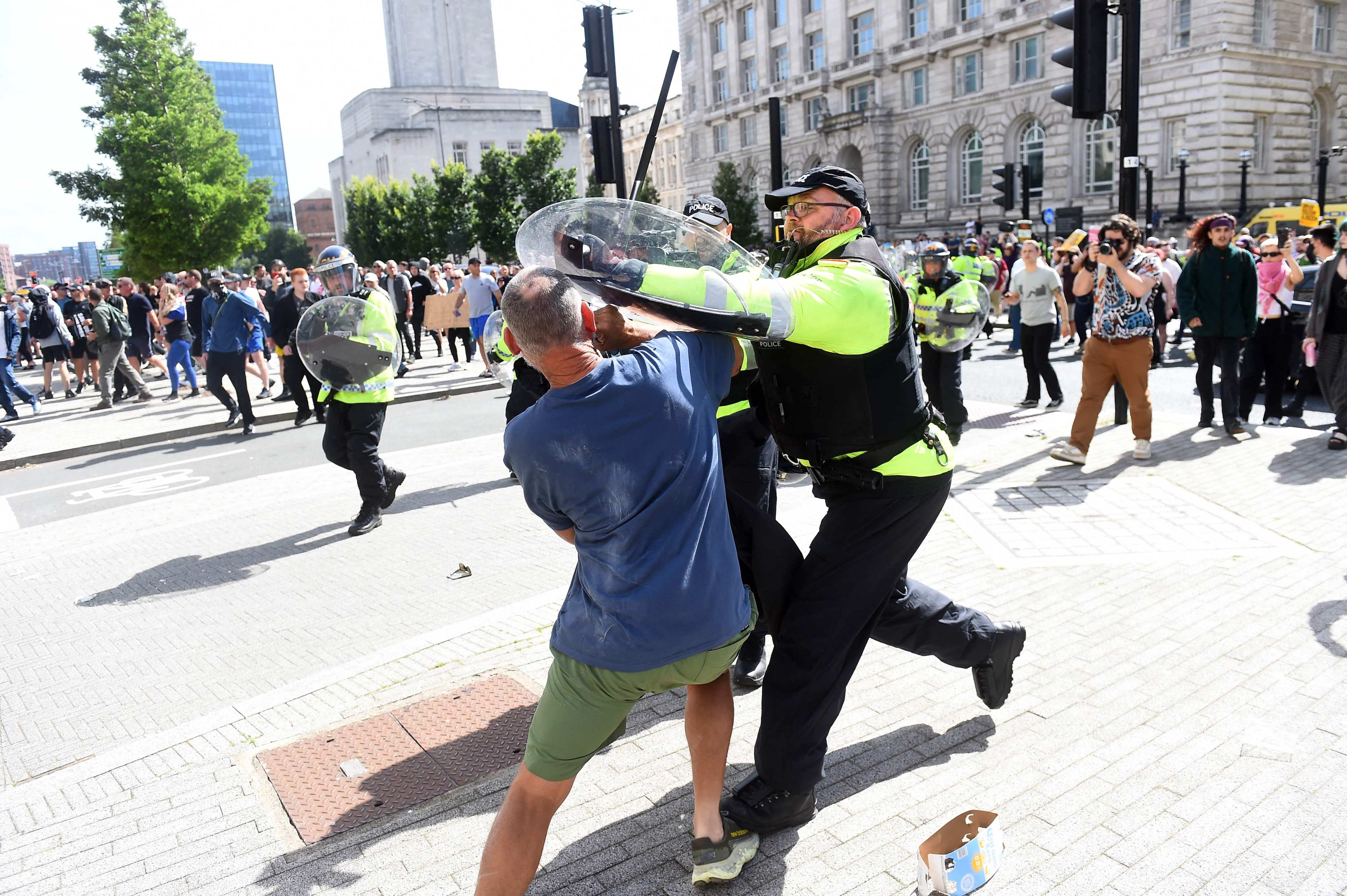 An officer tries to restrain a protester in Liverpool on August 3. The demonstrations were triggered by a mass stabbing incident. Photo: AFP