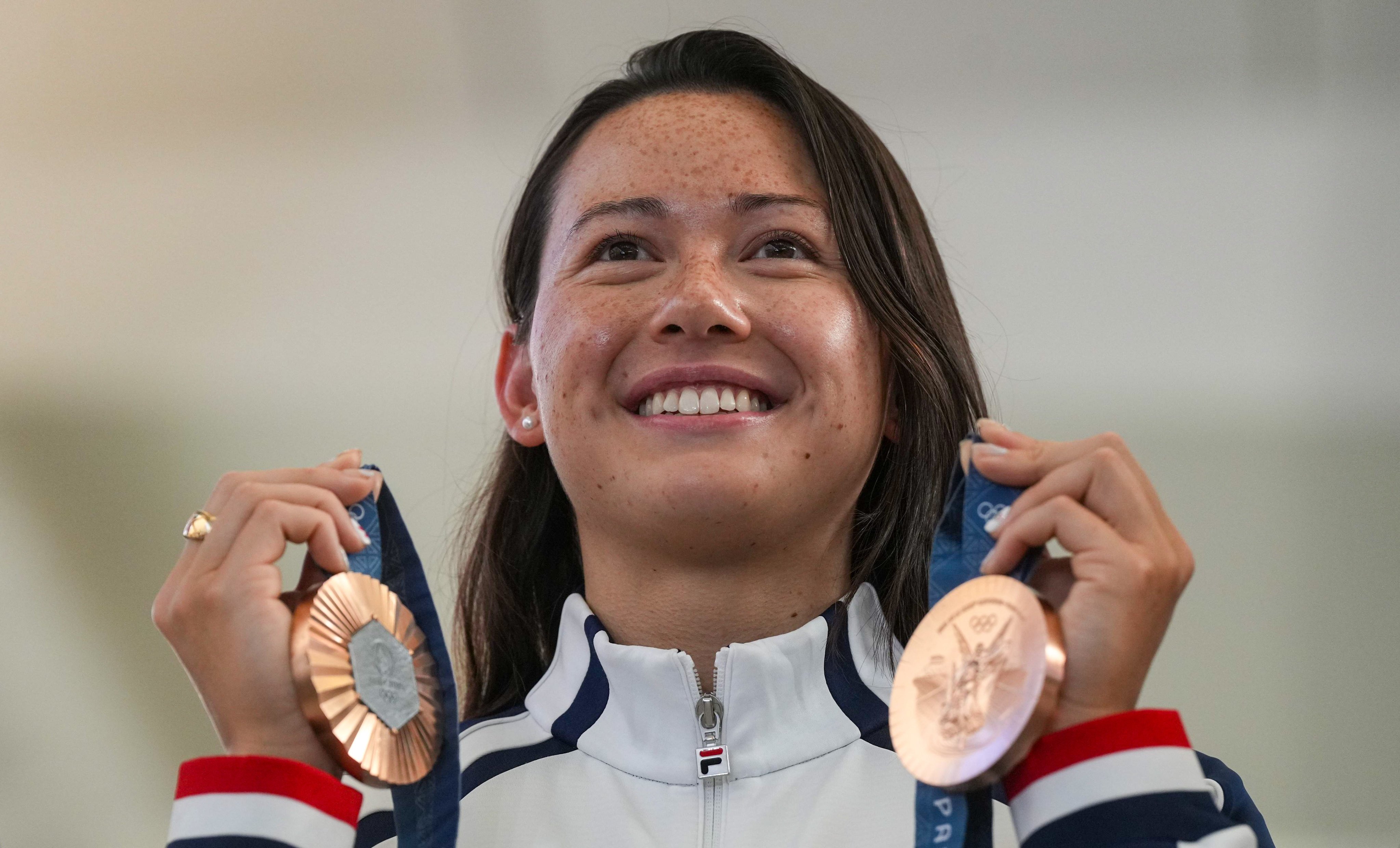 Olympic swimming star Siobhan Haughey holds up her medals as she arrives in Hong Kong. Photo: Elson Li