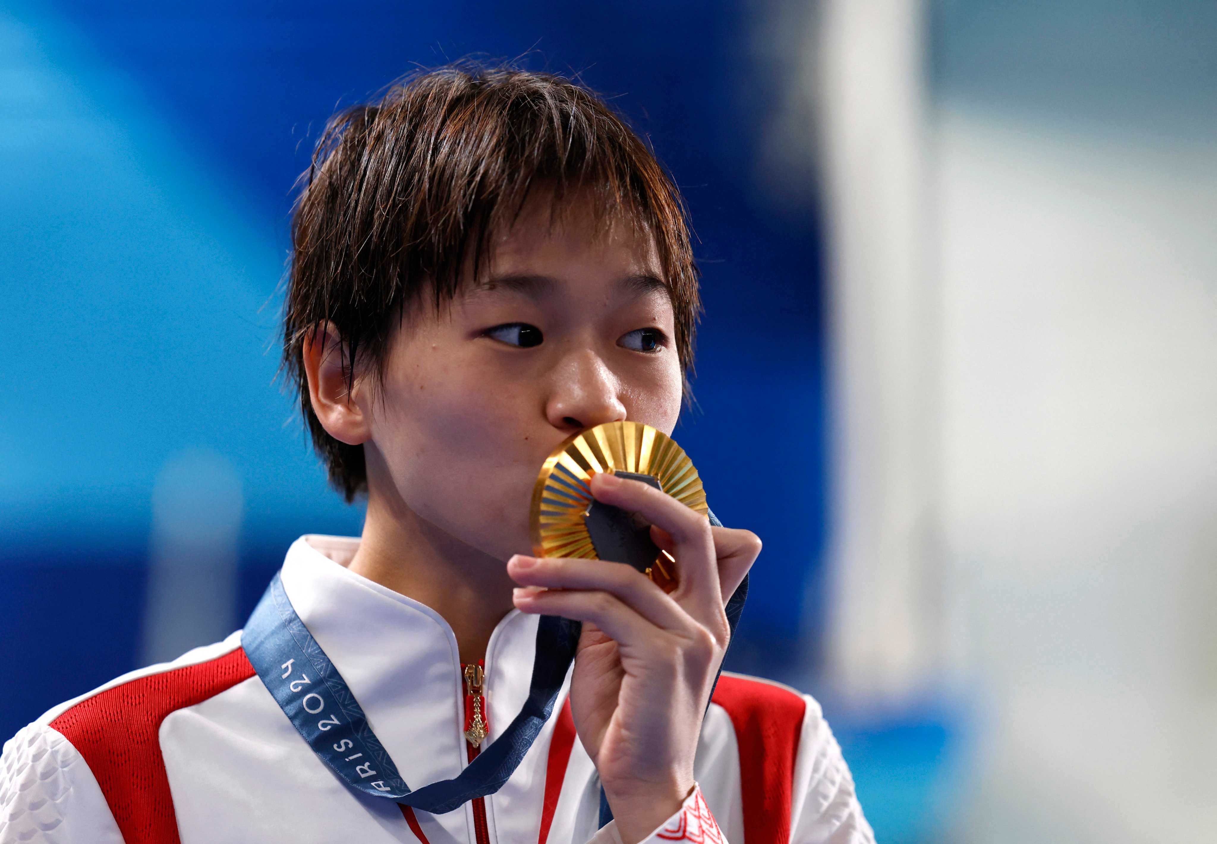 China’s Quan Hongchan kisses her gold medal after winning her third at the Olympics during the Paris Games. Photo: Reuters
