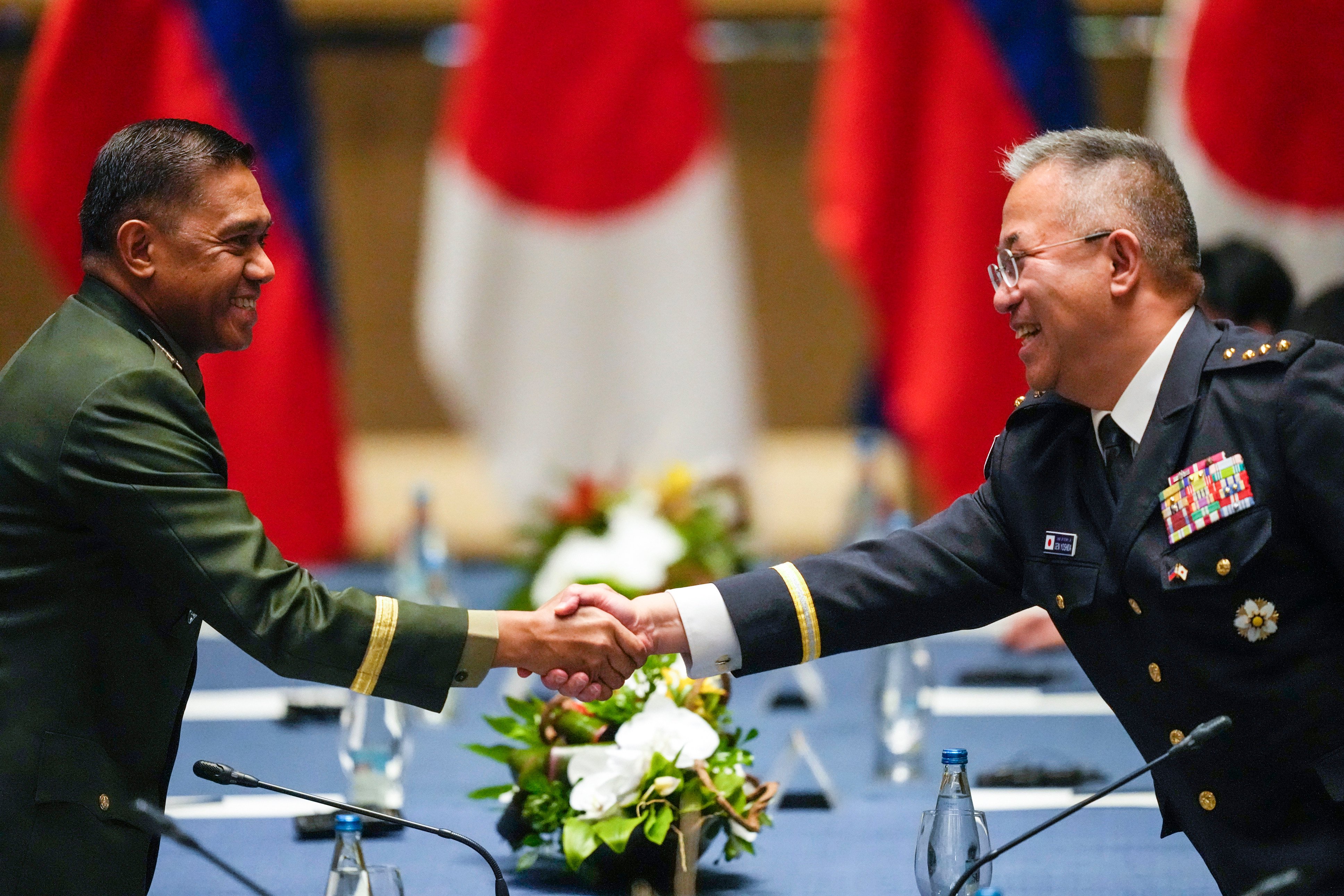 Philippine military chief General Romeo Brawner Jnr (left) shakes hands with Japan Self-Defense Force Chief of Staff General Yoshihide Yoshida as they arrive before meetings with Philippine and Japanese foreign and defence ministers at a hotel in Taguig, Philippines, on July 8. Japan and the Philippines have signed a defense pact allowing their troops to enter each other’s country. Photo: AP 