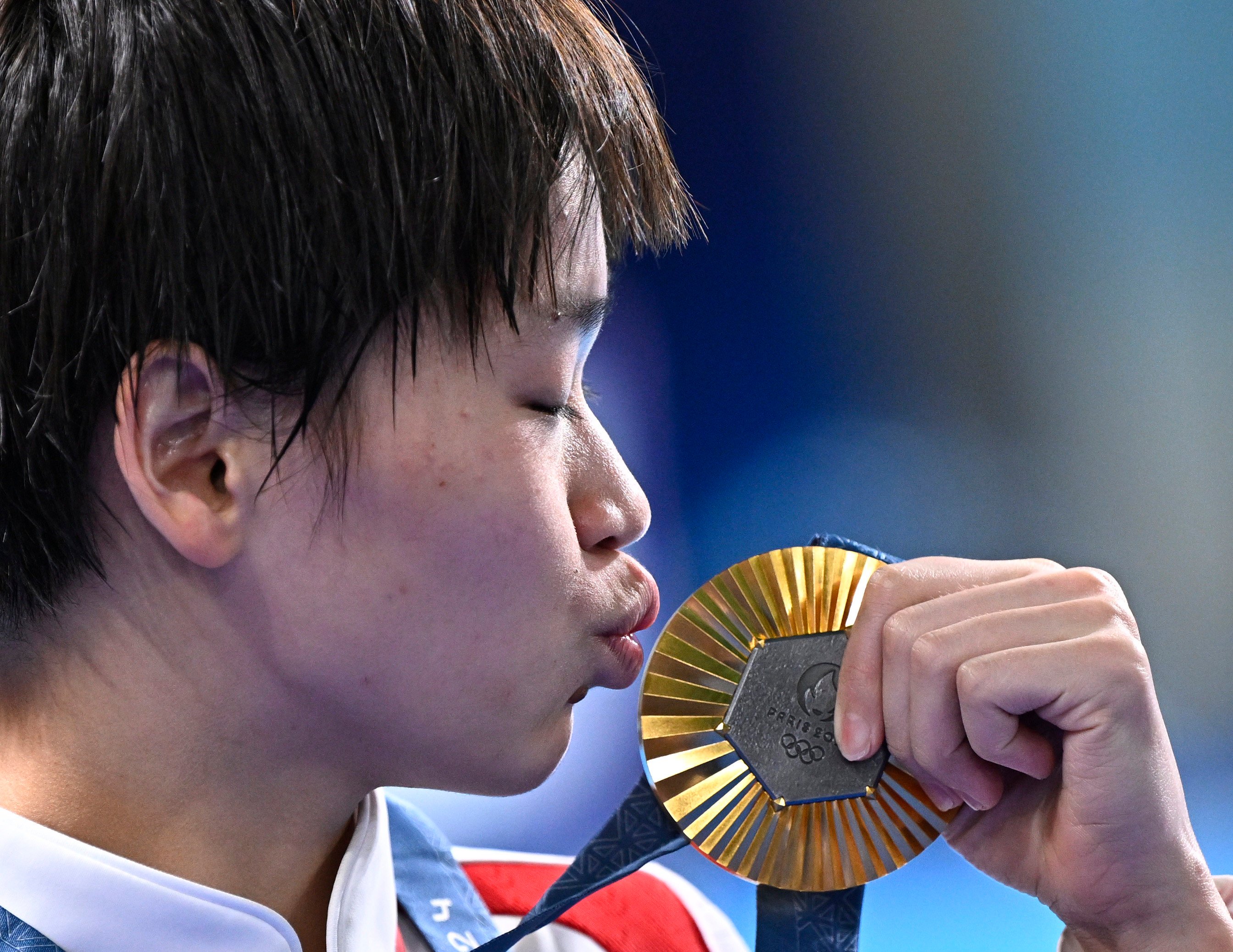 Quan Hongchan kisses her gold medal after winning the women’s 10m platform final. Photo: Xinhua