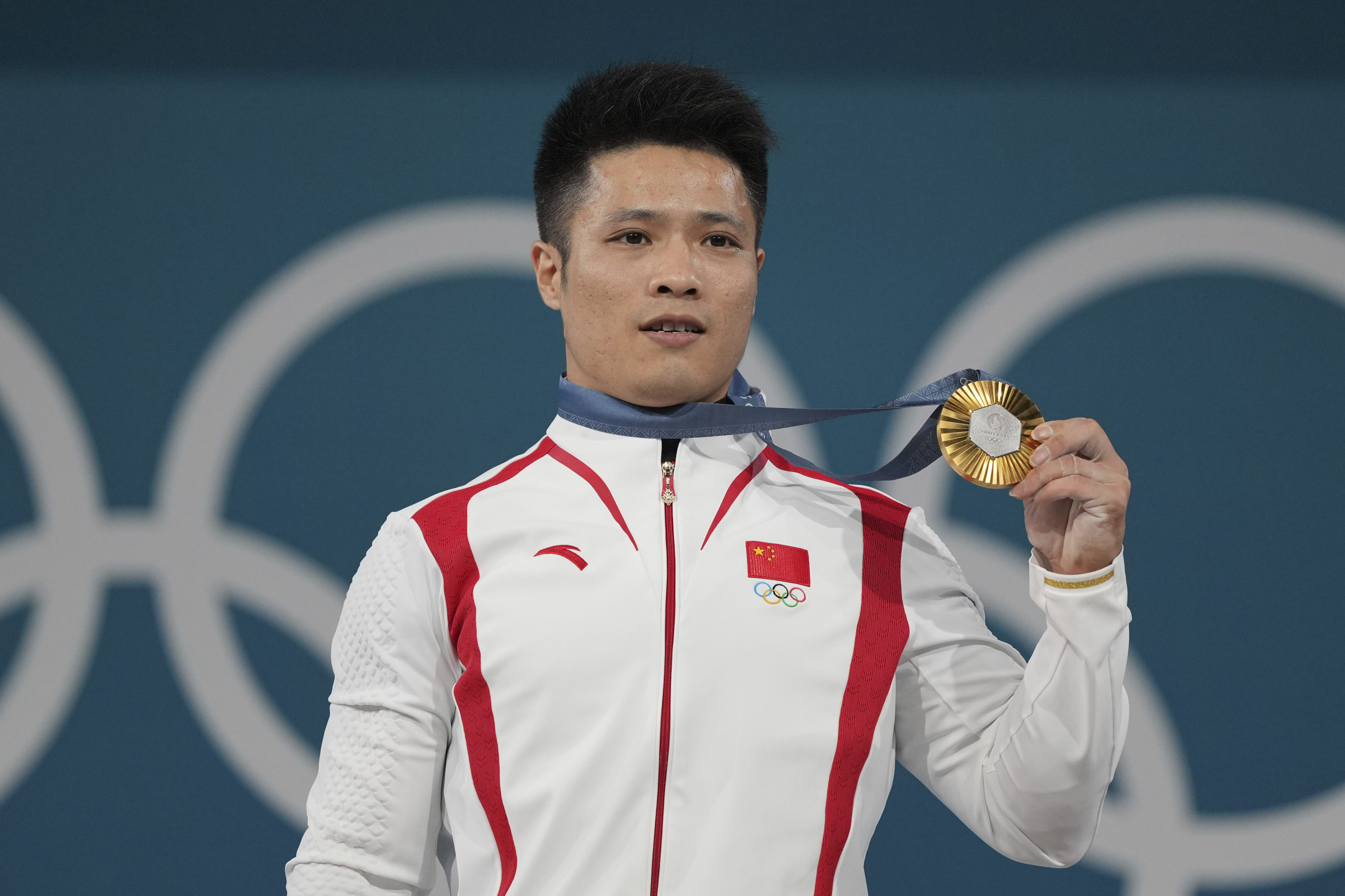 Li Fabin of China wears his gold medal for the men’s 61kg weightlifting. Photo: AP