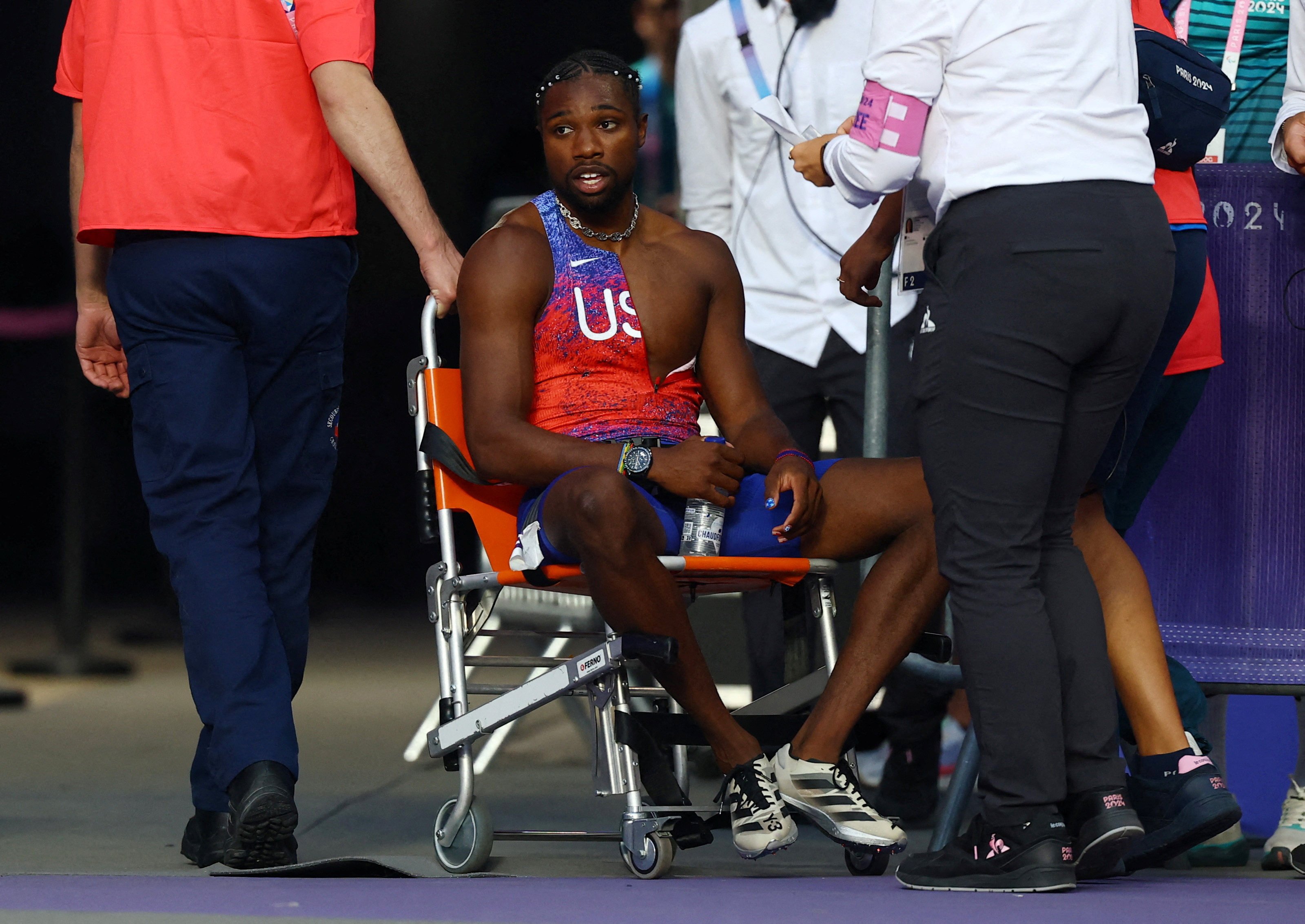 Noah Lyles (far left) receives care from medical staff following the men’s Olympic 200m final. Photo: Reuters