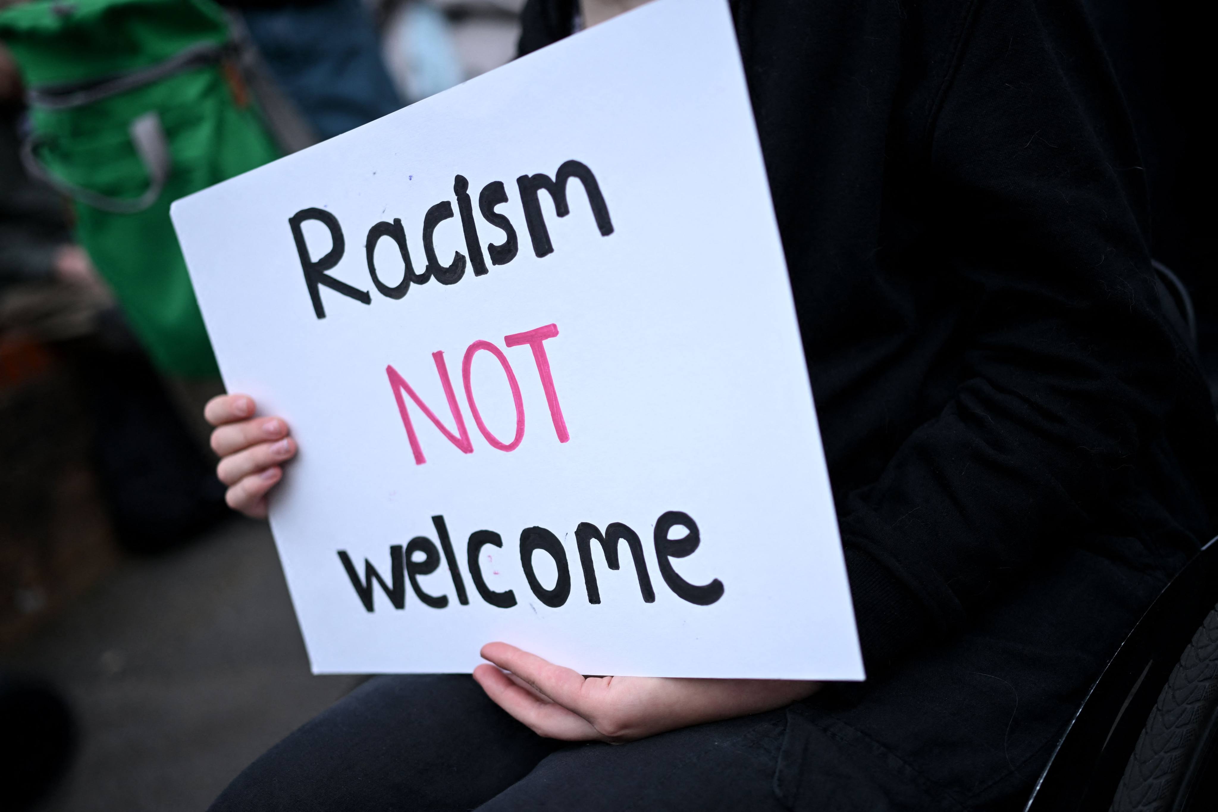 A protester holds a sign during a counter-demonstration against an anti-immigration protest in Oxford, England on August 7, 2024. Photo: AFP