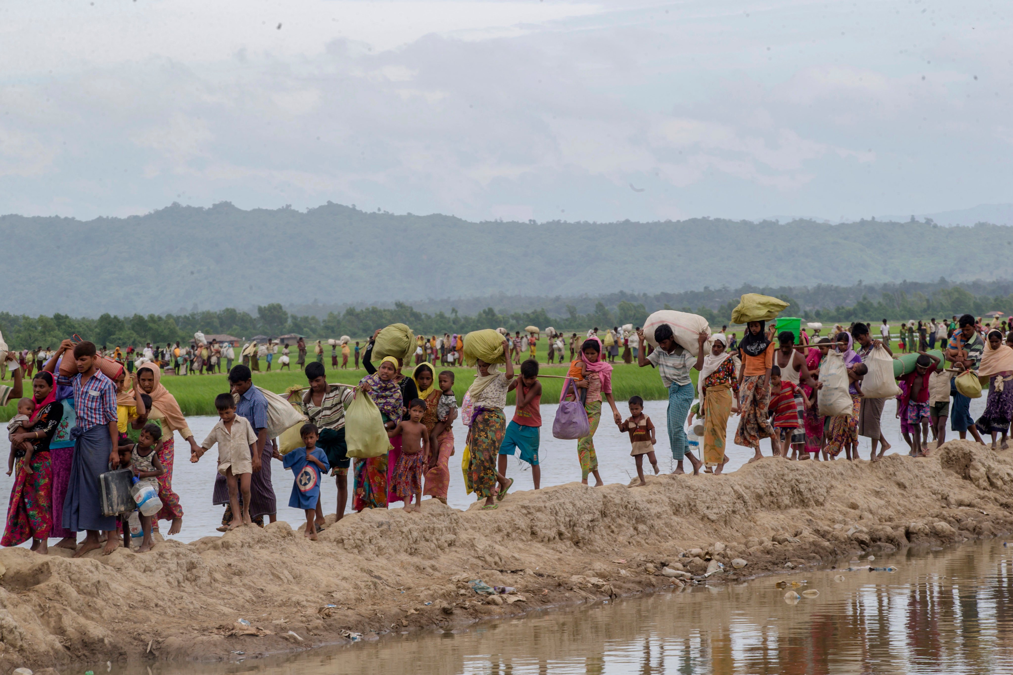 Rohingya Muslims who spent four days in the open after crossing over from Myanmar into Bangladesh, carry their belongings towards a refugee camp in Bangladesh, in October, 2017. Photo: AP