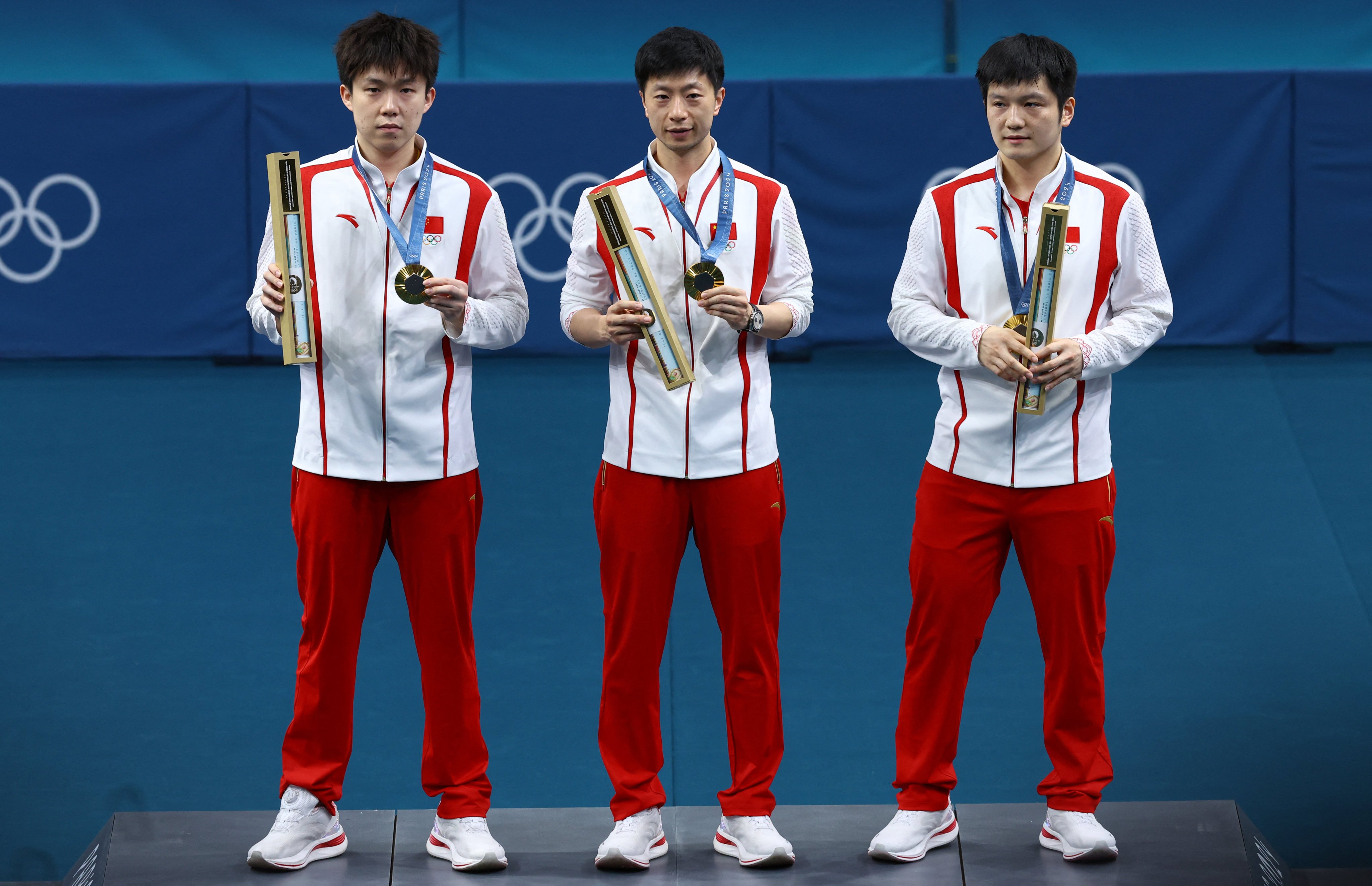 Ma Long (centre) with Wang Chuqin (left) and Fan Zhendong after winning the men’s team table tennis gold, Ma’s sixth at the Olympics. Photo: Reuters