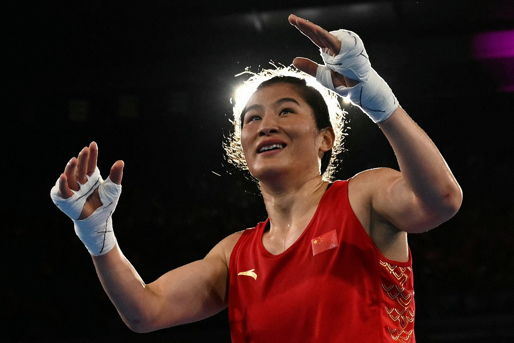 Li Qian celebrates beating Caitlin Parker of Australia in the semi-finals of the women’s 75kg category. Photo: Reuters