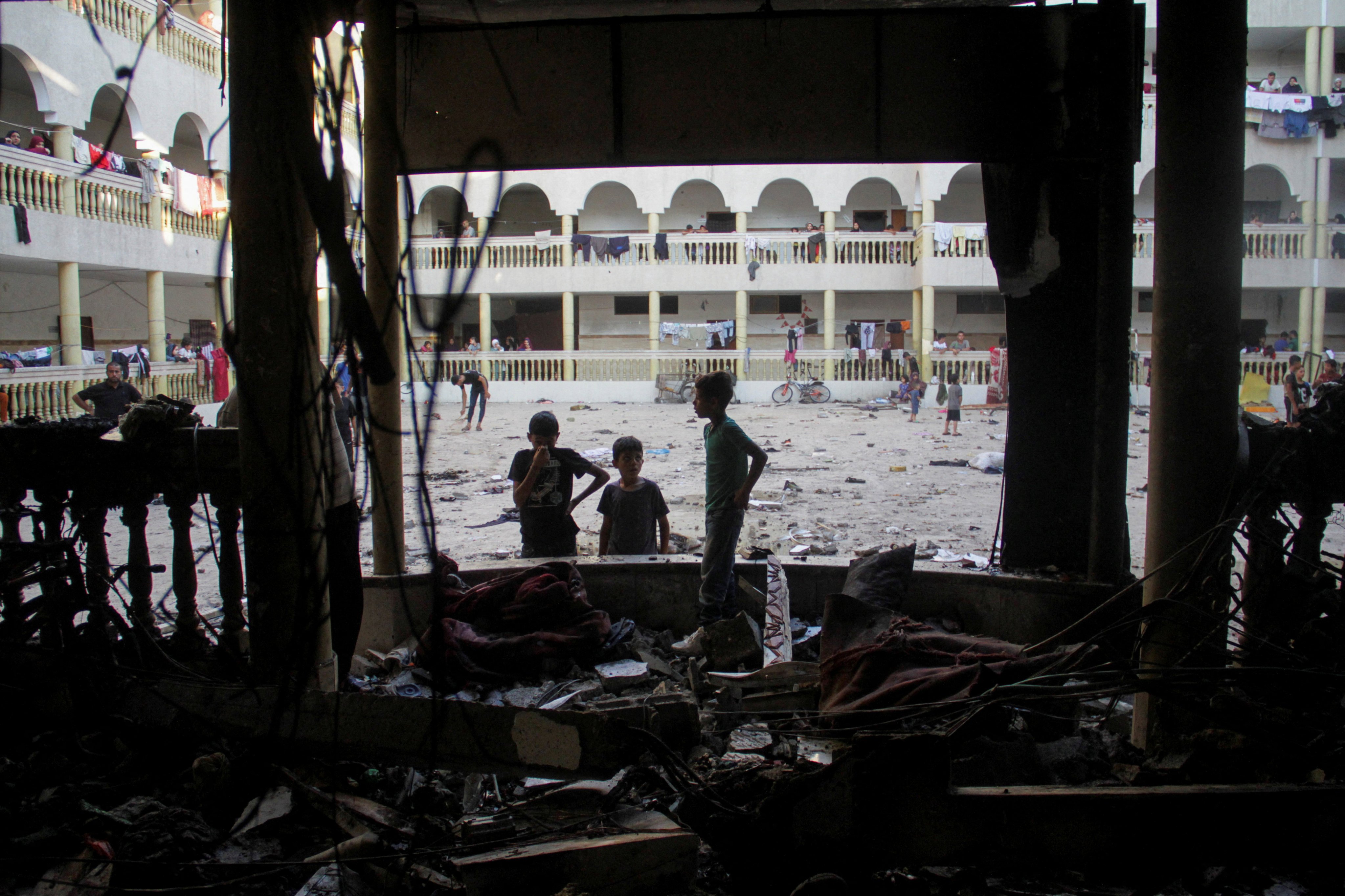 Children inspect the damage to a school sheltering displaced people following an Israeli airstrike, Gaza City. Photo: Reuters