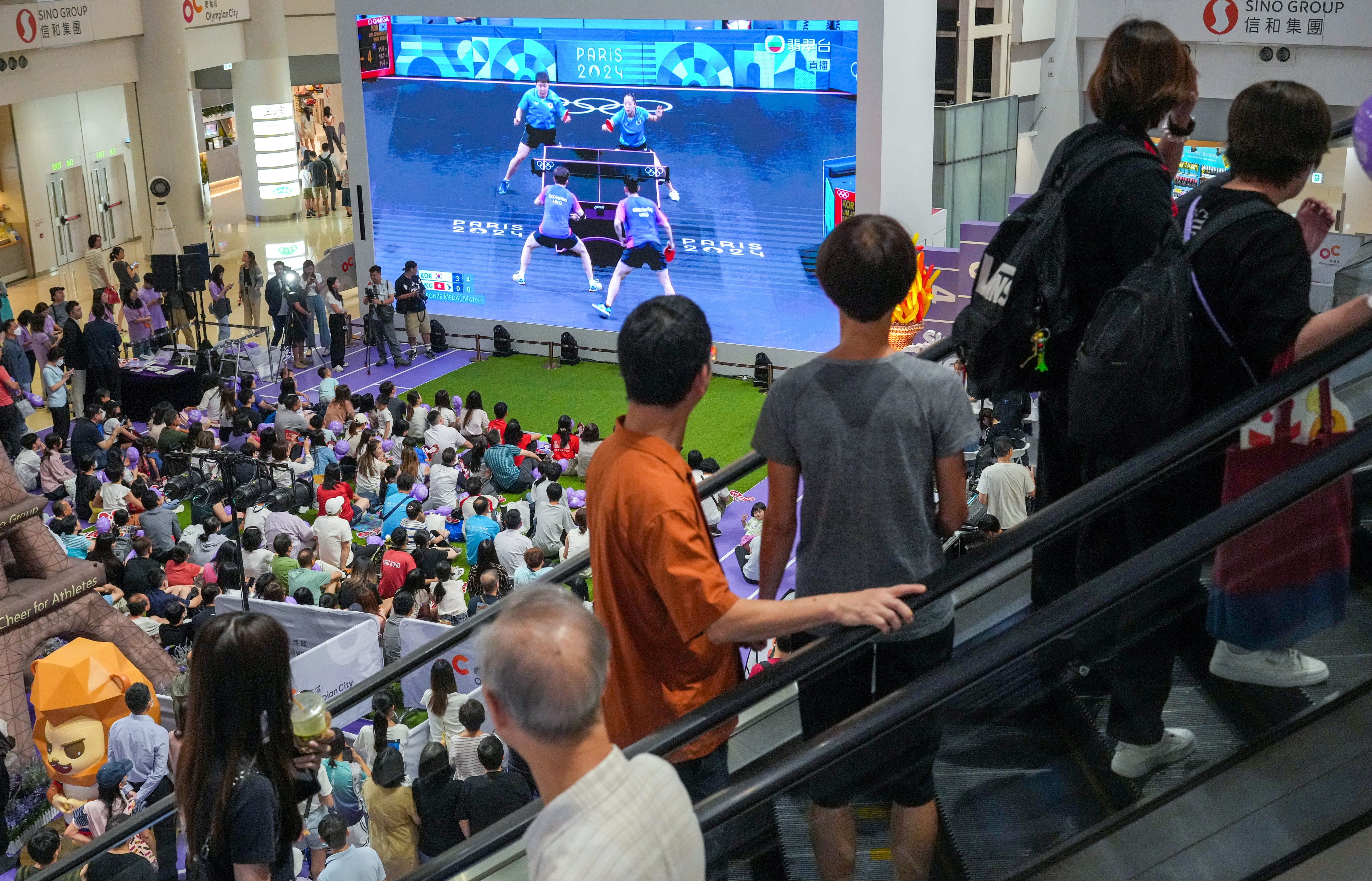 Mall-goers watch Hong Kong table tennis athletes compete against South Korea during the Paris Games. Photo: May Tse