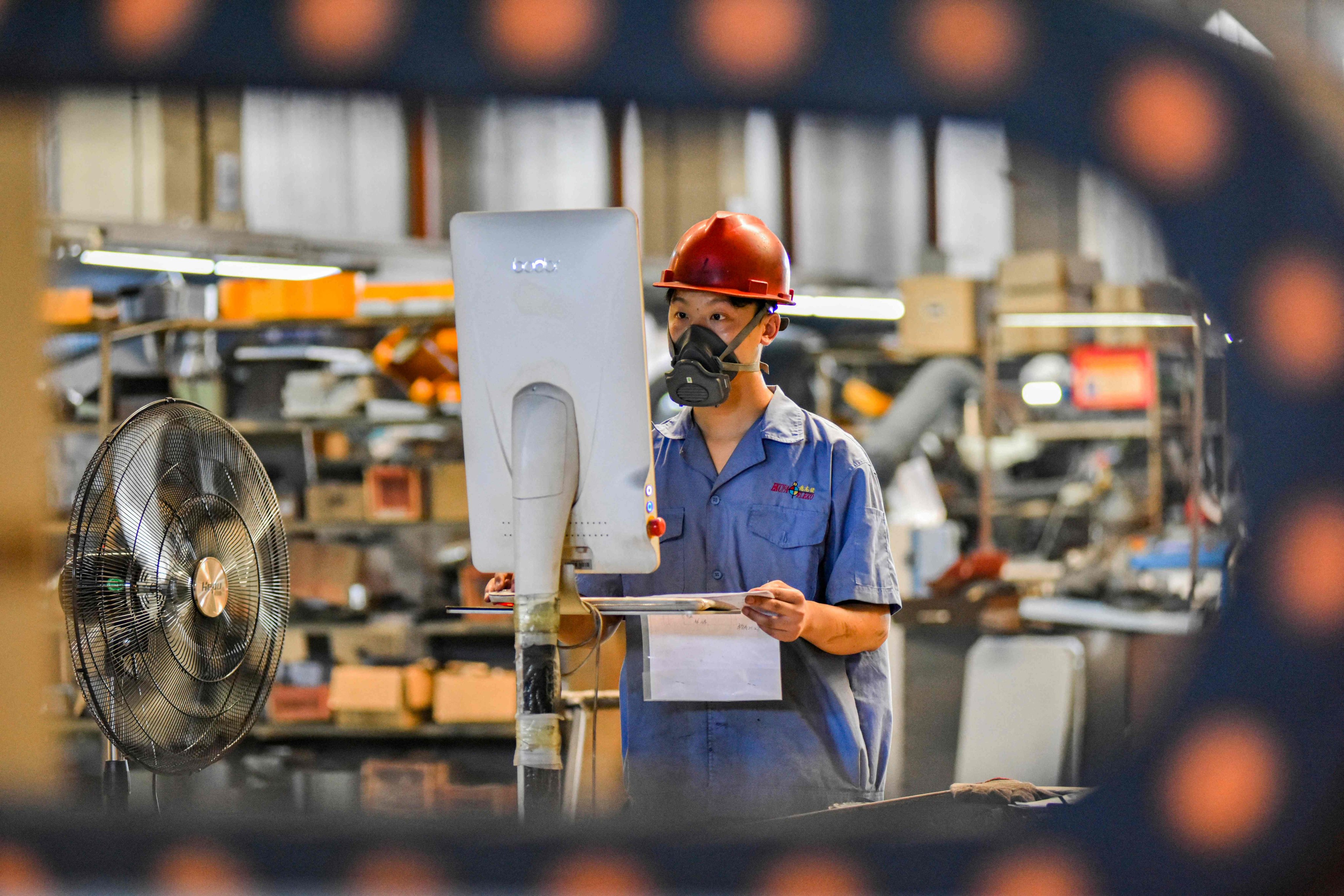 An employee works on a machine part production line at a printing and packaging factory in Qingzhou, in eastern China’s Shandong province. Photo: AFP