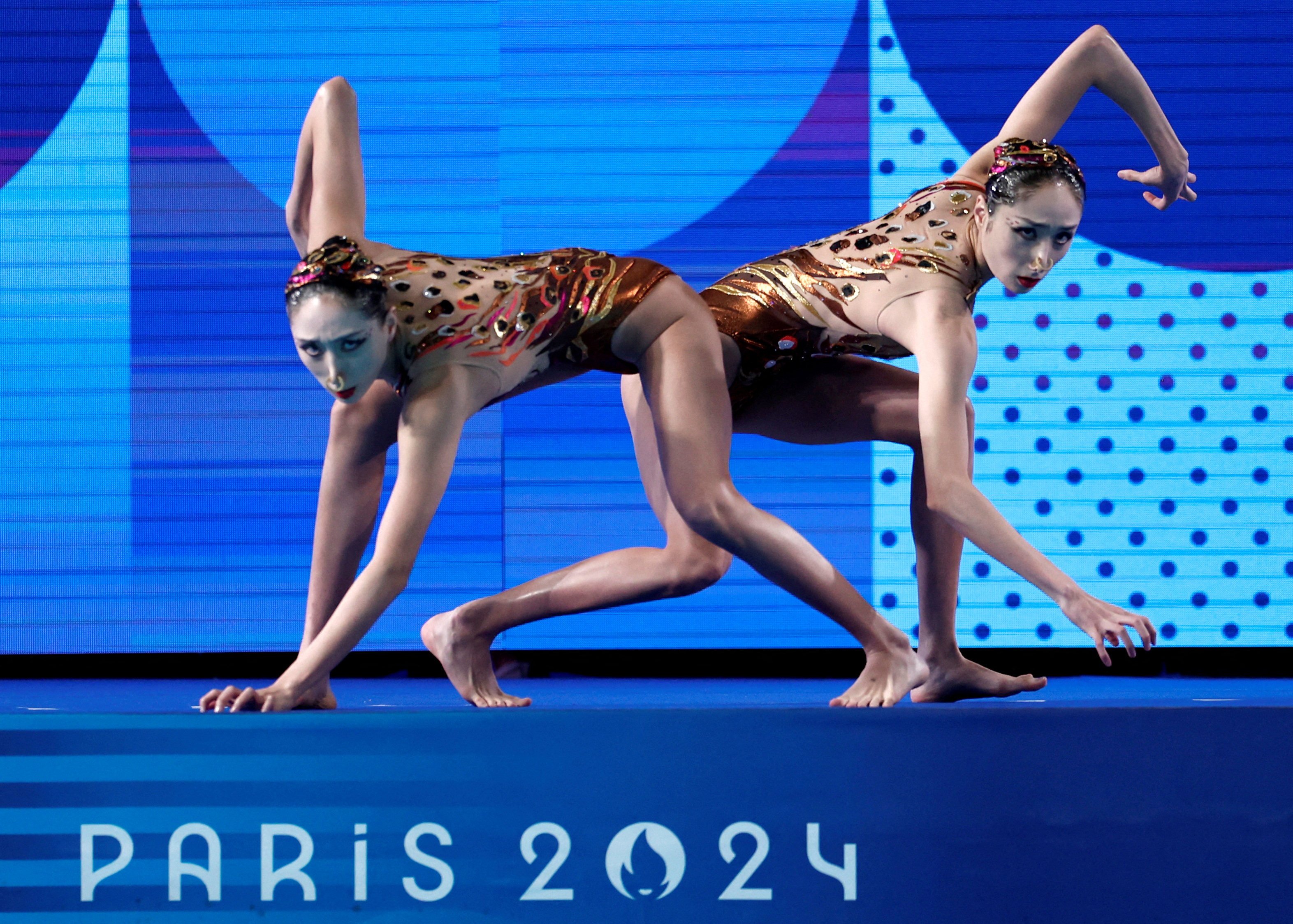 Chinese gold medallists Wang Liuyi and Wang Qianyi began their free routine in dramatic fashion, crawling like panthers to the edge of the water before diving in. Photo: Reuters