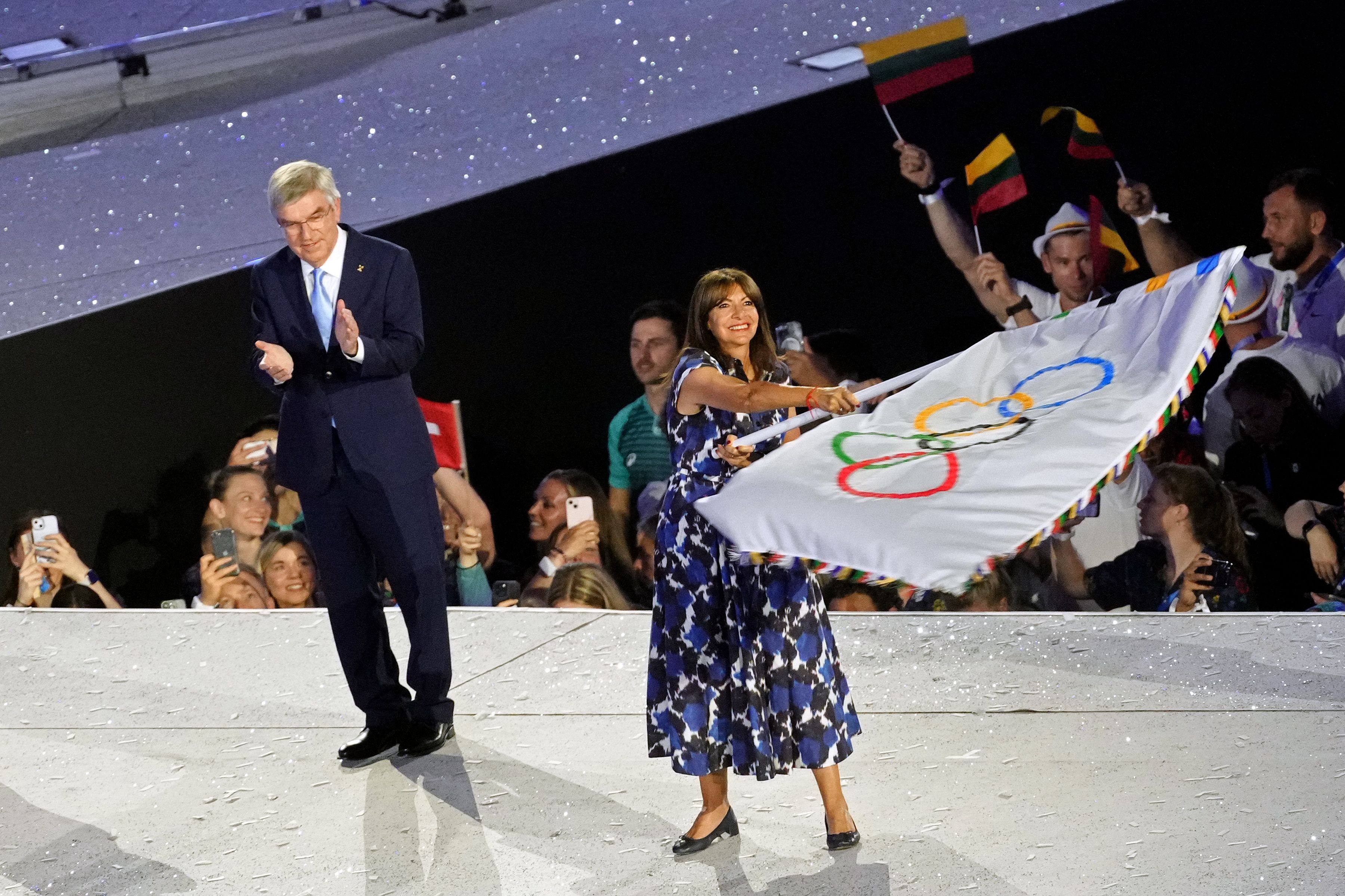 Paris mayor Anne Hidalgo (right) waves the Olympic flag next to International Olympic Committee president Thomas Bach during closing ceremony. Photo: AFP