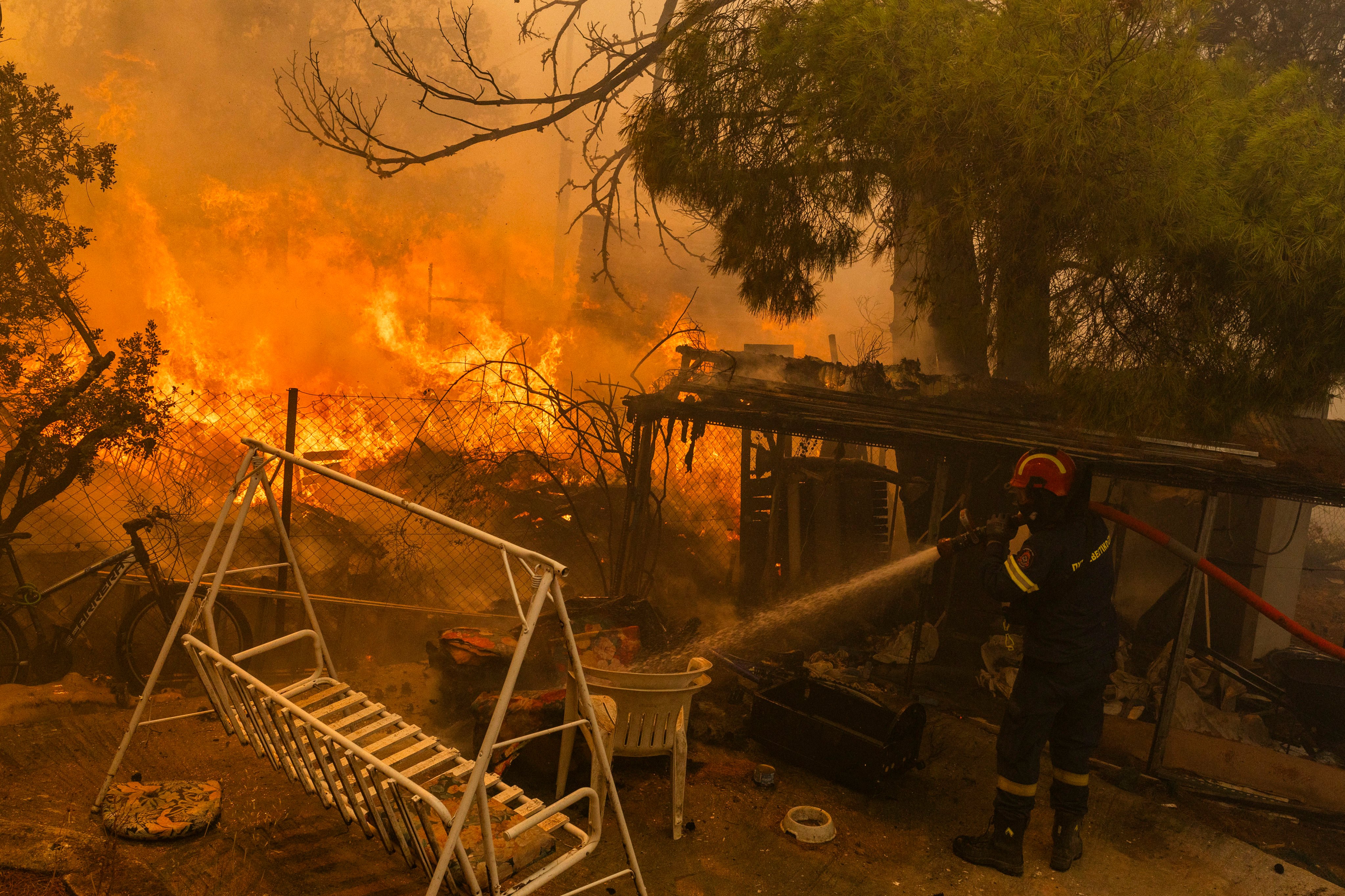 A firefighter works to extinguish a large fire outside Athens, Greece on Monday. Photo: dpa