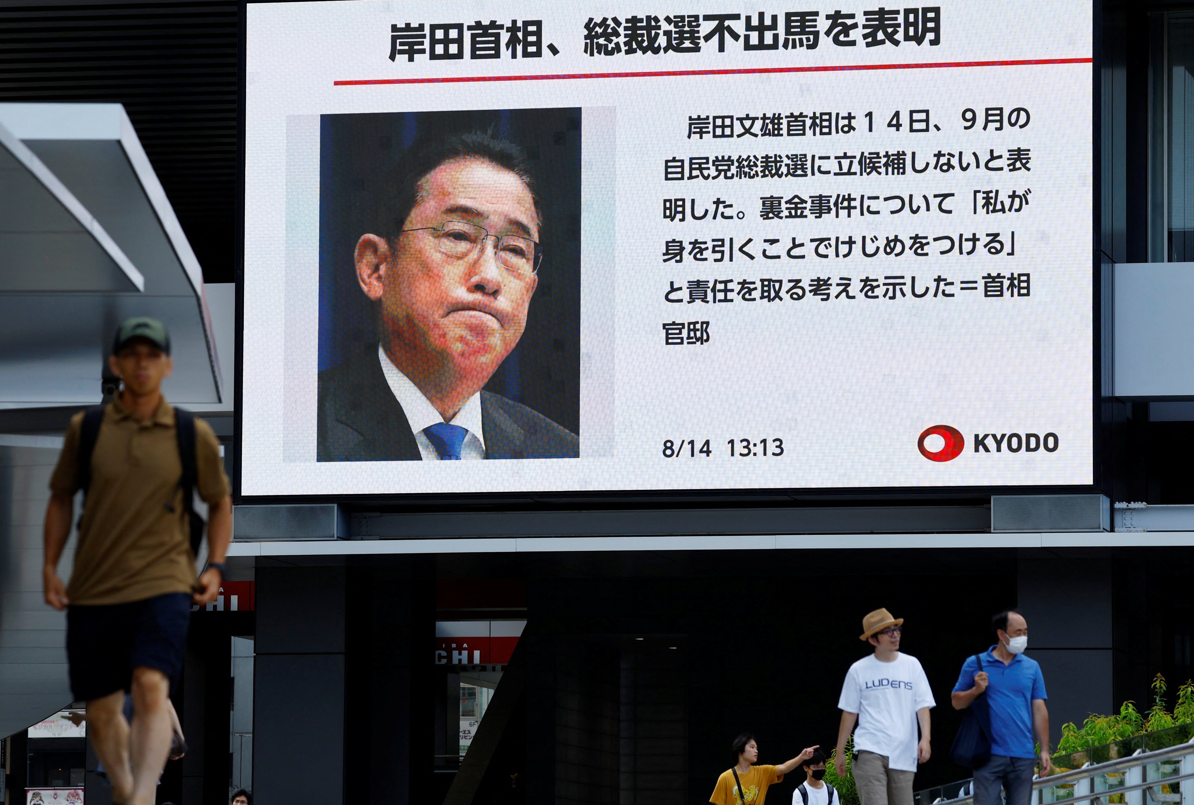 People walk past a large screen in Tokyo displaying news about Japanese Prime Minister Fumio Kishida’s announced resignation as LDP leader. Photo: Reuters