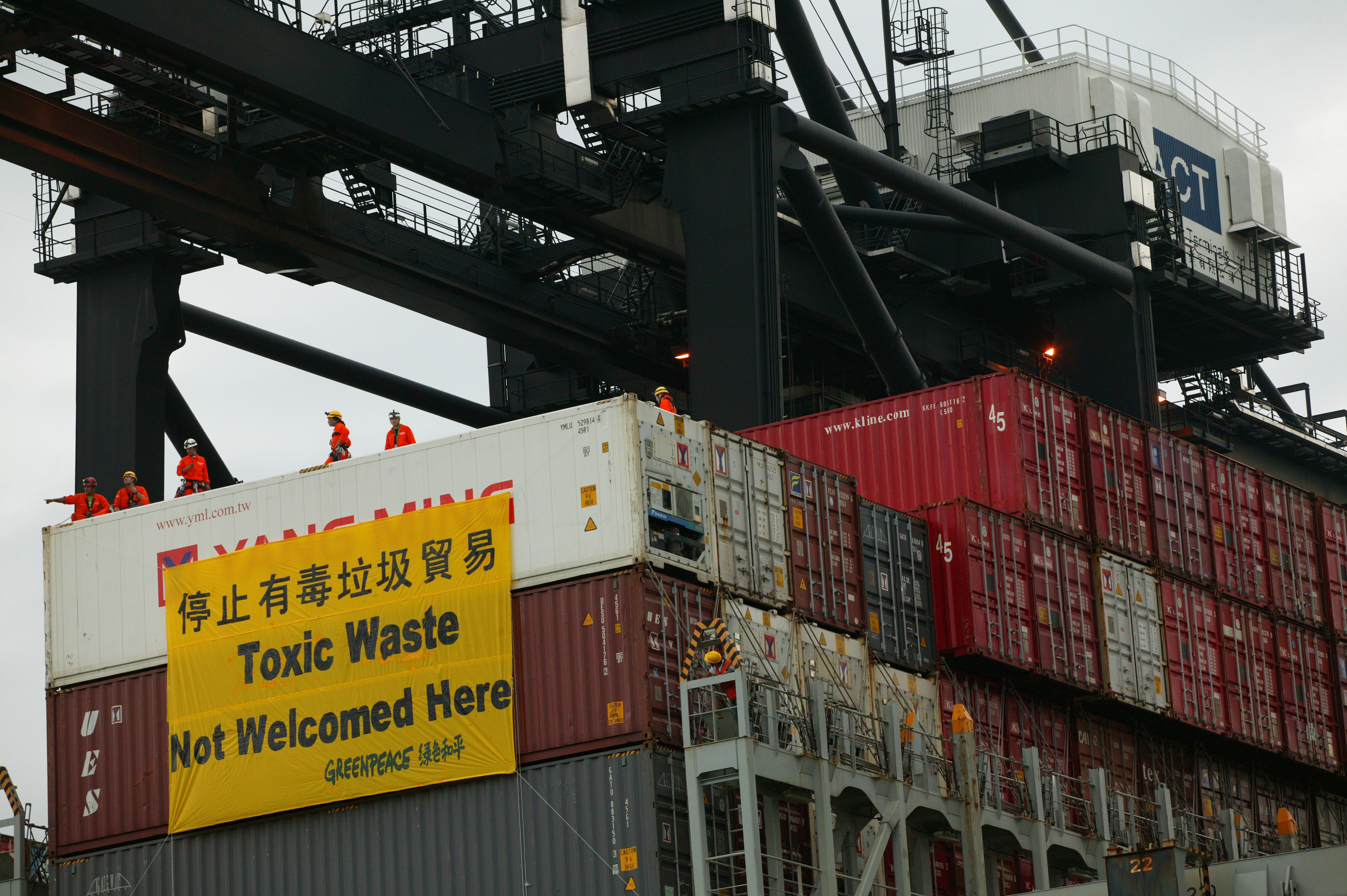 Greenpeace activists hang a banner on a cargo container loaded with electronic waste during a demonstration. Containers bound for Thailand allegedly filled with tons of hazardous industrial waste from Albania are now slated to return to Europe. Photo: SCMP/File