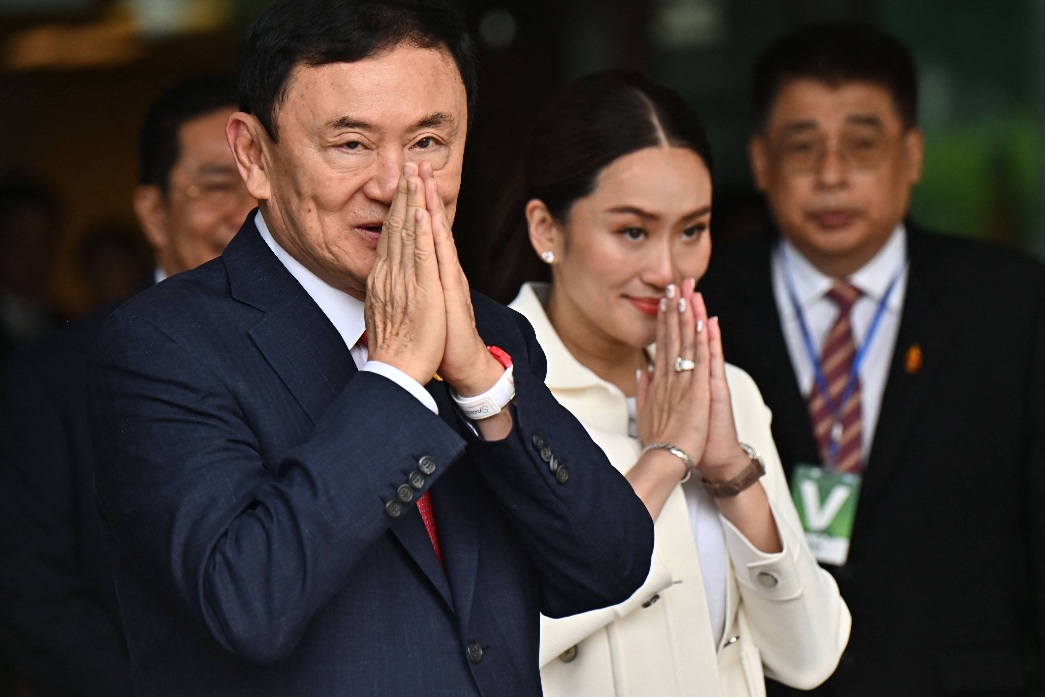 Former Thai prime minister Thaksin Shinawatra greets supporters with his youngest daughter Paetongtarn. Photo: AFP