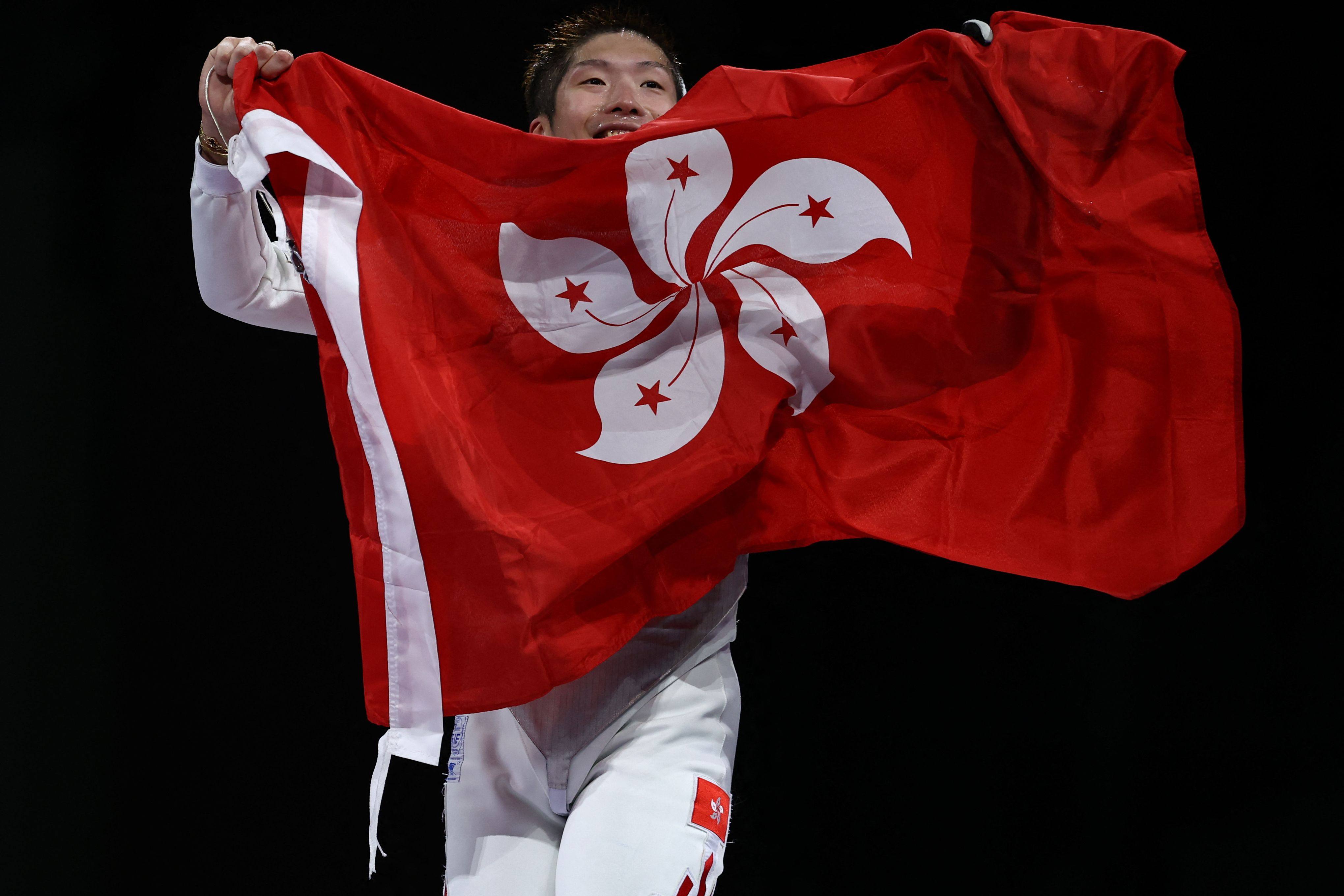 Cheung Ka-long unfurls a Hong Kong flag as he celebrates his Olympic gold in Paris. Photo: AFP