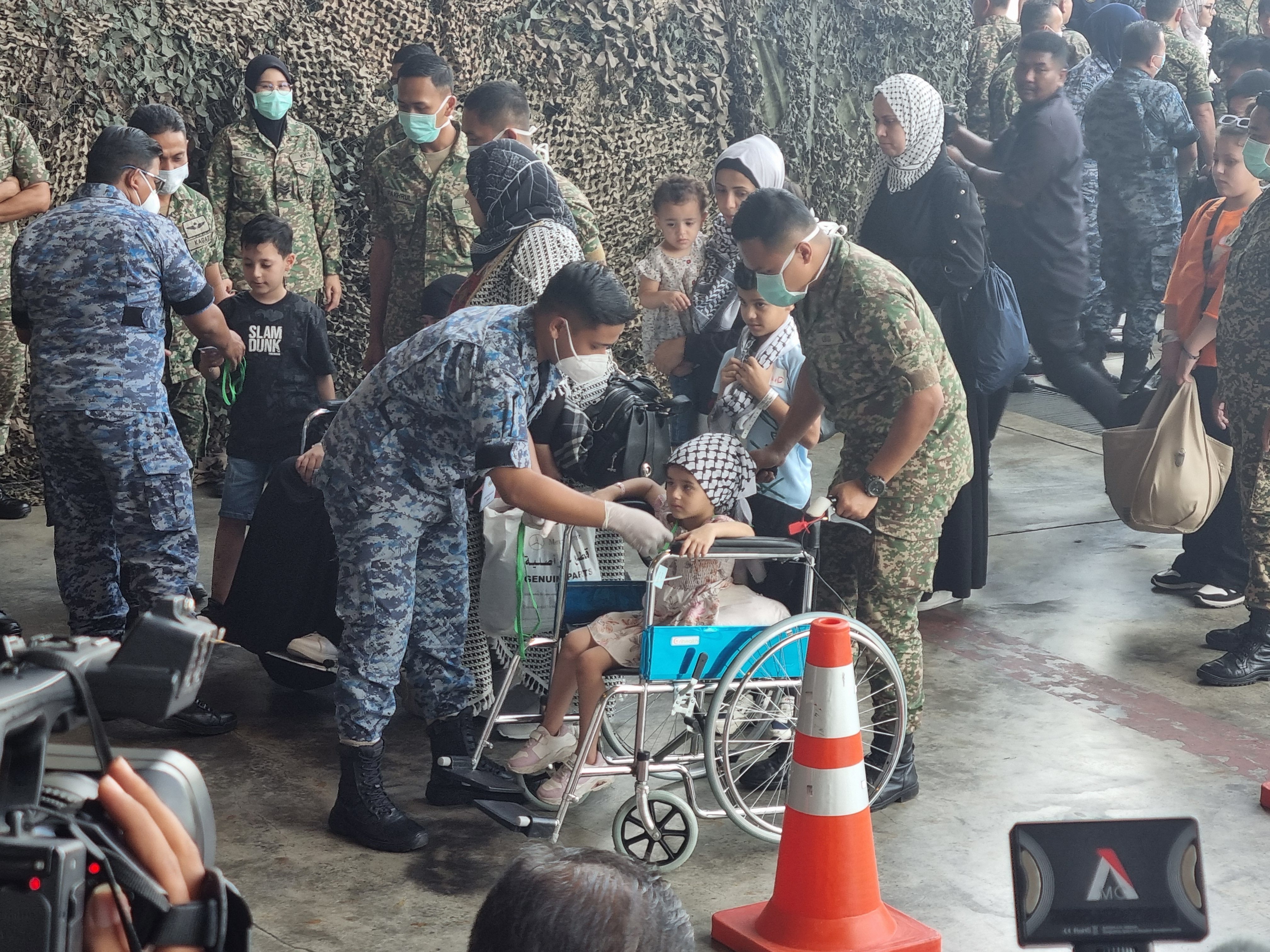 Malaysian armed forces personnel escort patients and families that fled the Israel-Gaza war, into a field hospital at the Subang air force base. Photo: Joseph Sipalan