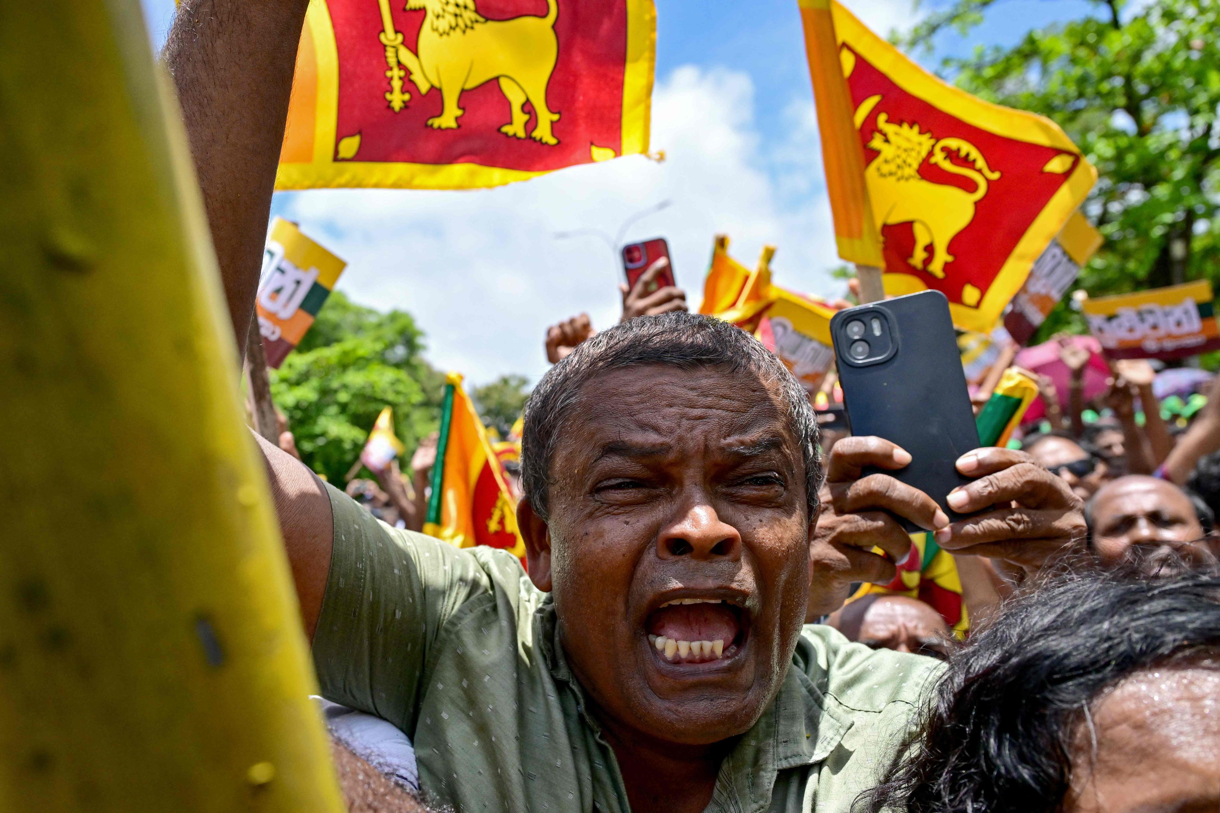 Supporters of Sri Lanka’s President Ranil Wickremesinghe cheer in Colombo on August 15 after he filed his papers for the coming presidential elections. Photo: AFP