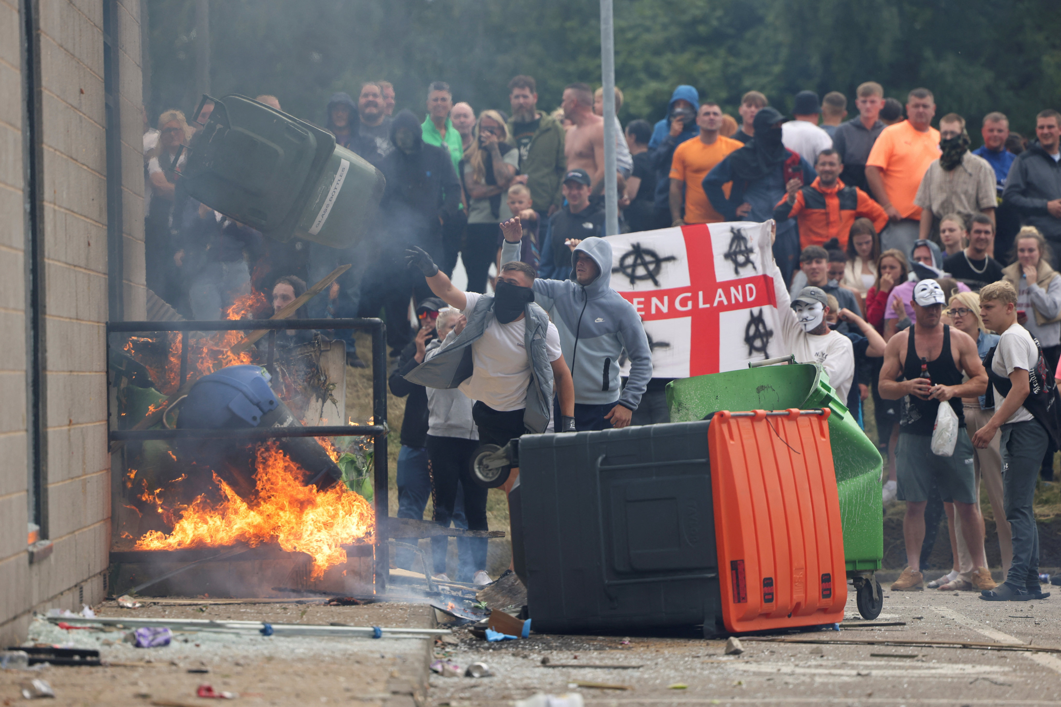 Demonstrators toss a trash bin during an anti-immigration protest in Rotherham, UK on August 4, 2024. Photo: Reuters