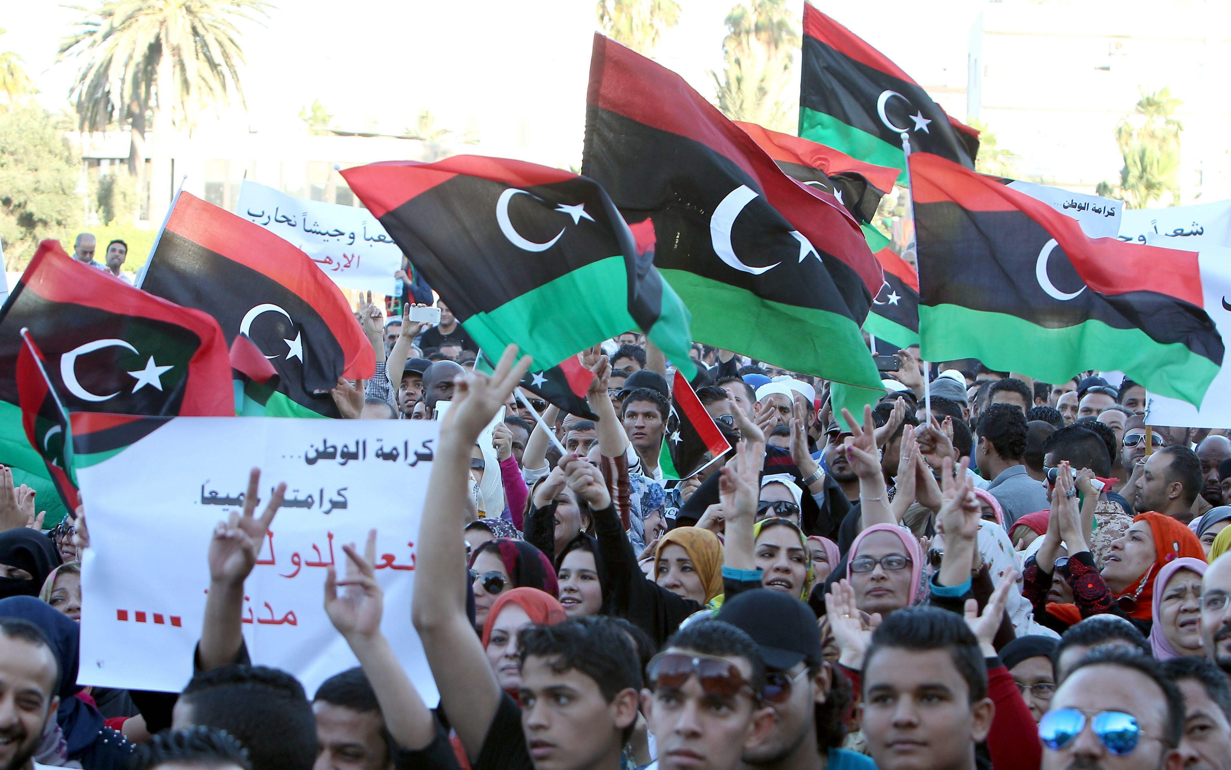 Libyan protesters hold placards and the national flag during a demonstration in Tripoli, in May, 2014. Photo: EPA