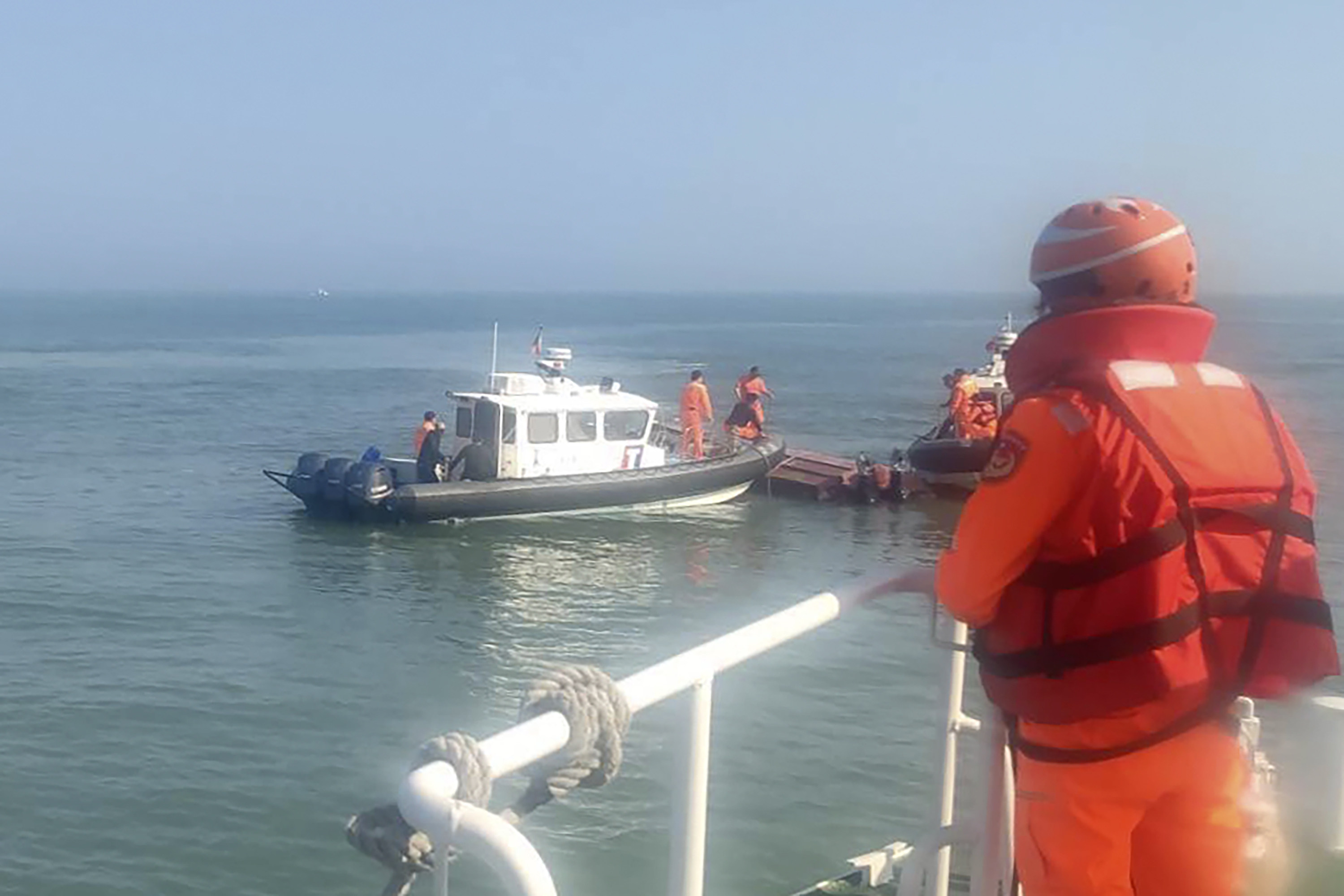 Taiwanese coast guards inspect a vessel that capsized during a chase off the coast of Kinmen archipelago in Taiwan in February that resulted in the death of two fishermen. Photo: Taiwan Coast Guard Administration via AP