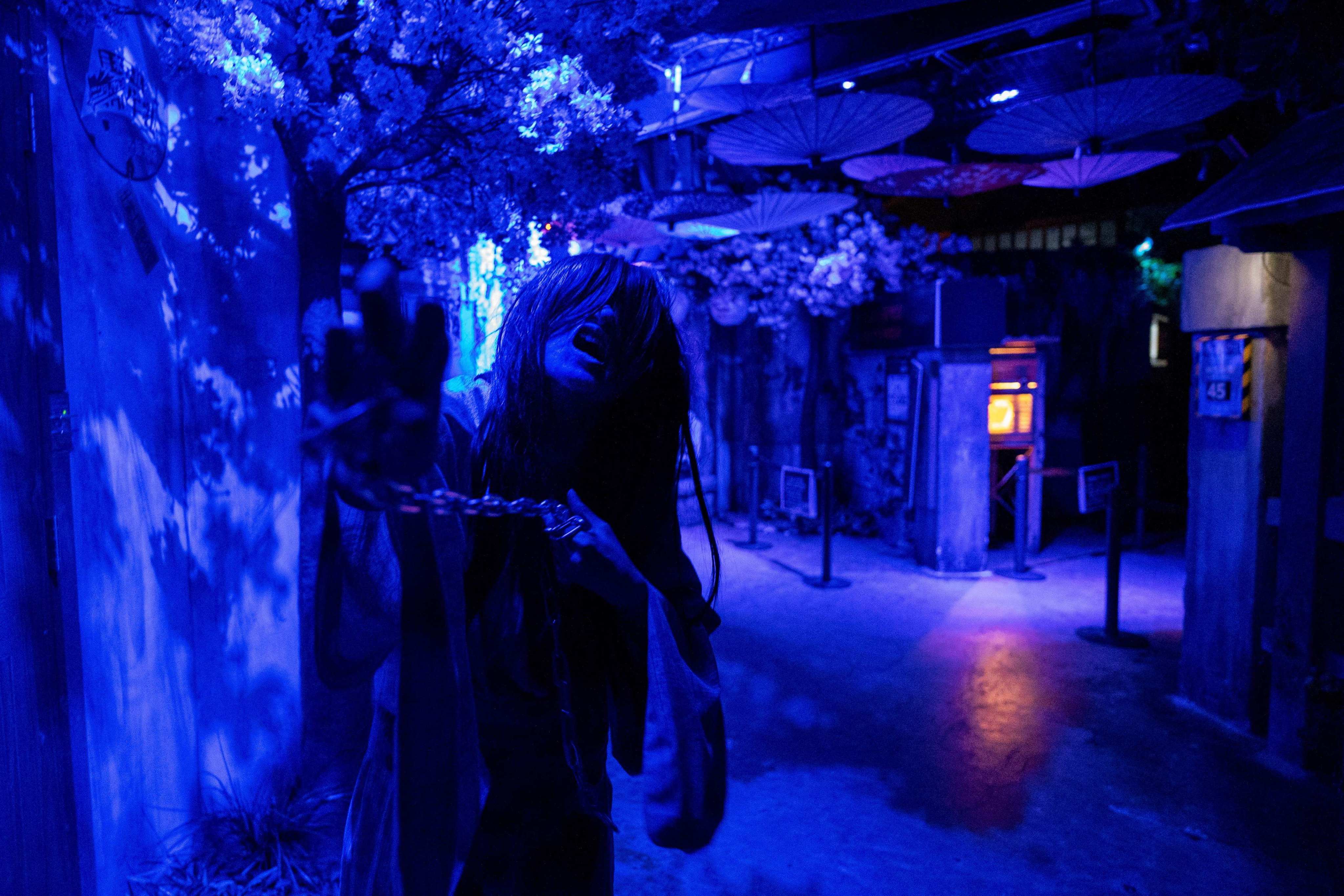 A kimono-clad performer roams around while groaning like a zombie at a haunted house of a theme park in Tokyo. Photo: AFP