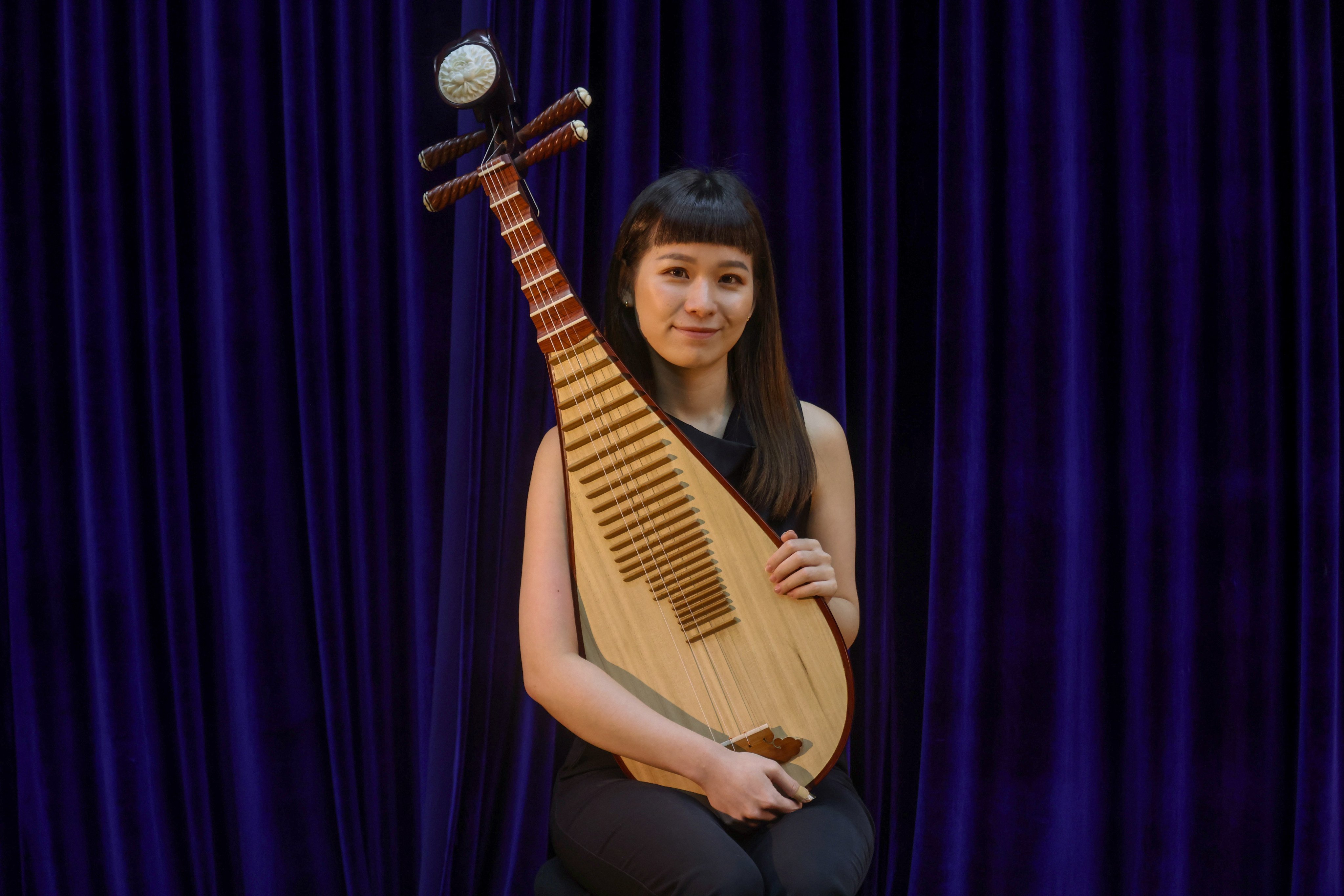 Hong Kong Chinese Orchestra member Wang Kaihan sits with her pipa. Photo: Jonathan Wong