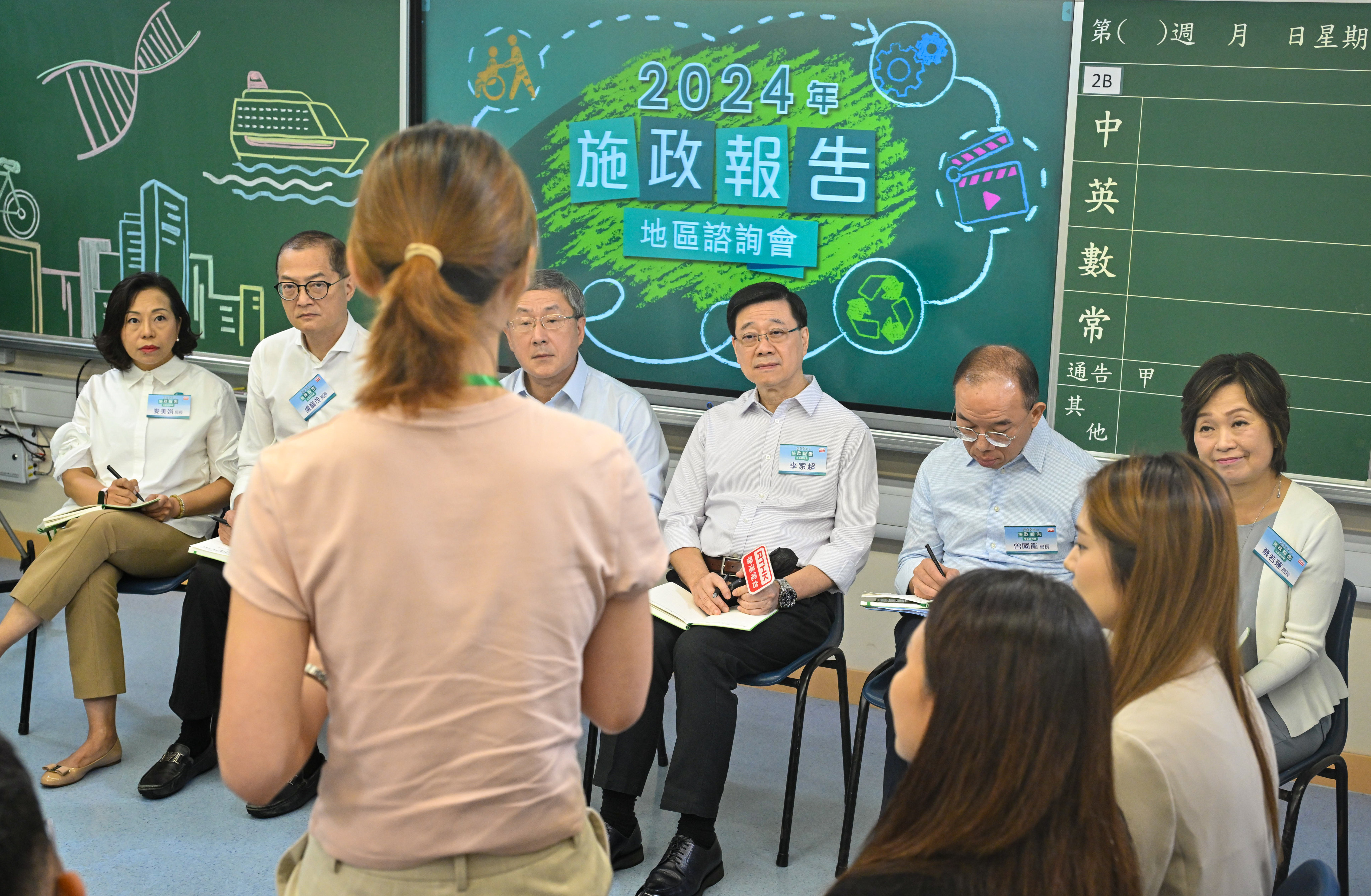 John Lee (third from right) listens to a member of the public at the 2024 Policy Address District Forum alongside other prinicpal officials on Sunday. Photo: ISD