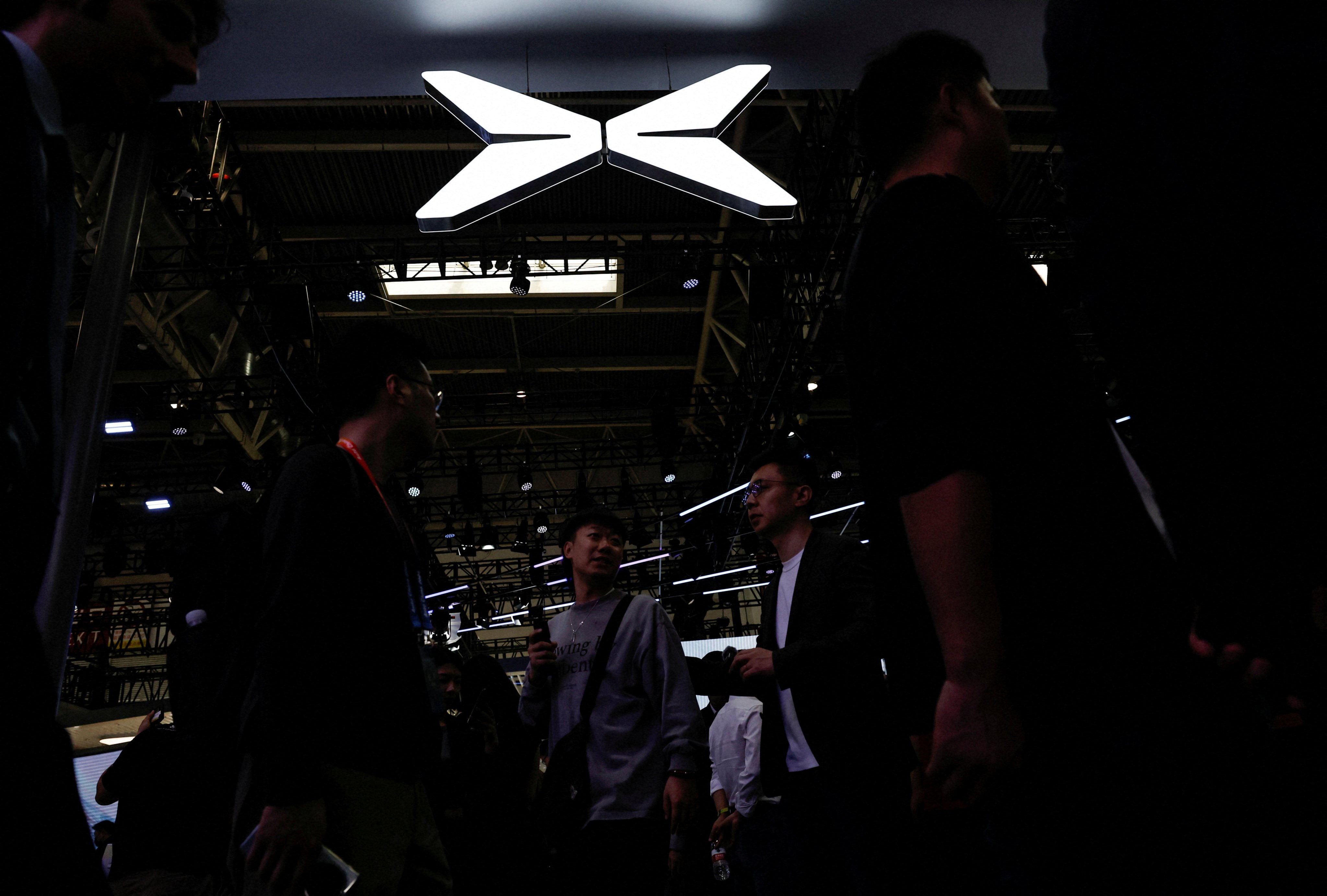 Visitors walk past an Xpeng logo at the Beijing International Automotive Exhibition in Beijing on April 25, 2024. Photo: Reuters