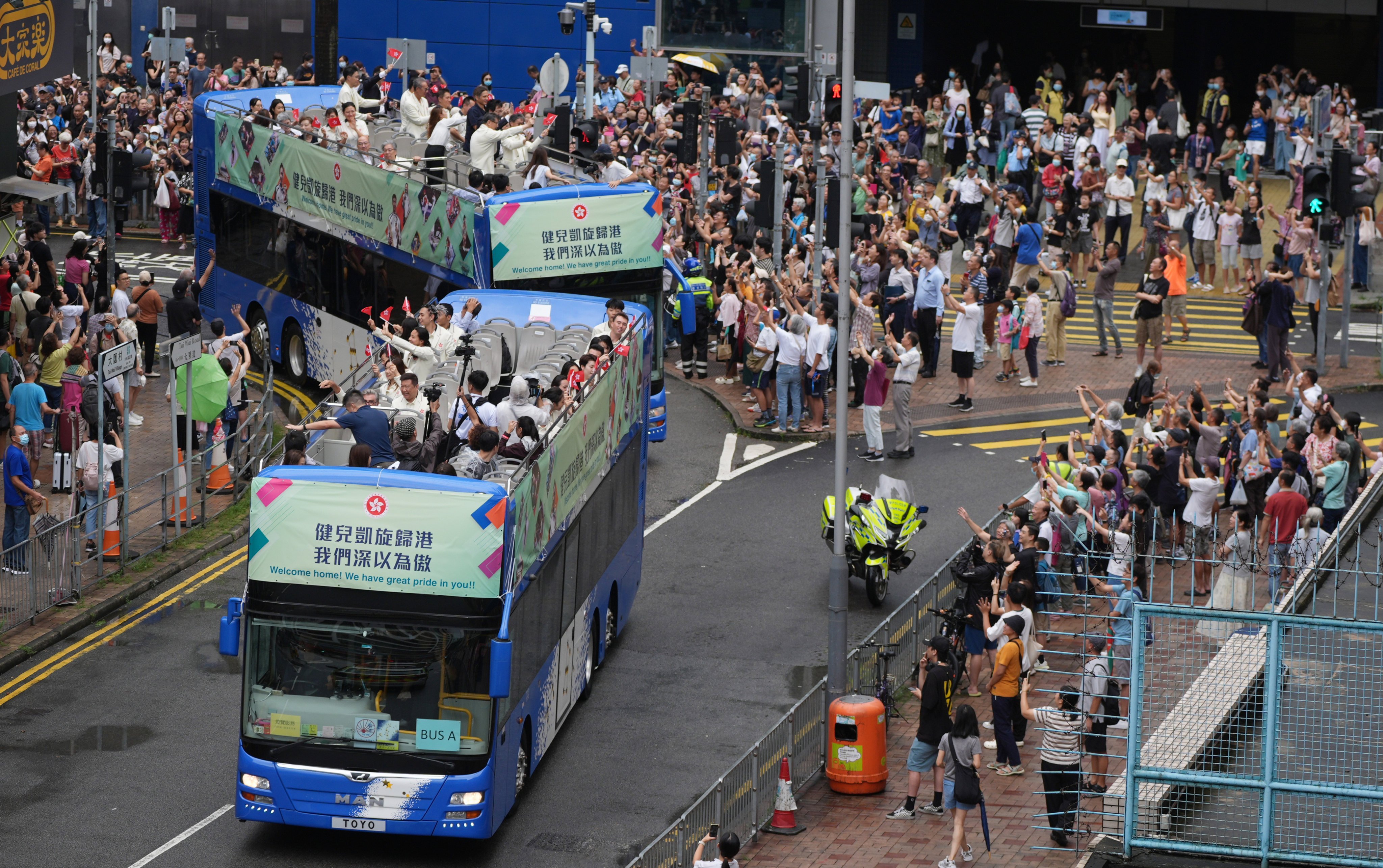 Olympic athletes wave to residents during their tour of the city on Wednesday. Photo: Eugene Lee