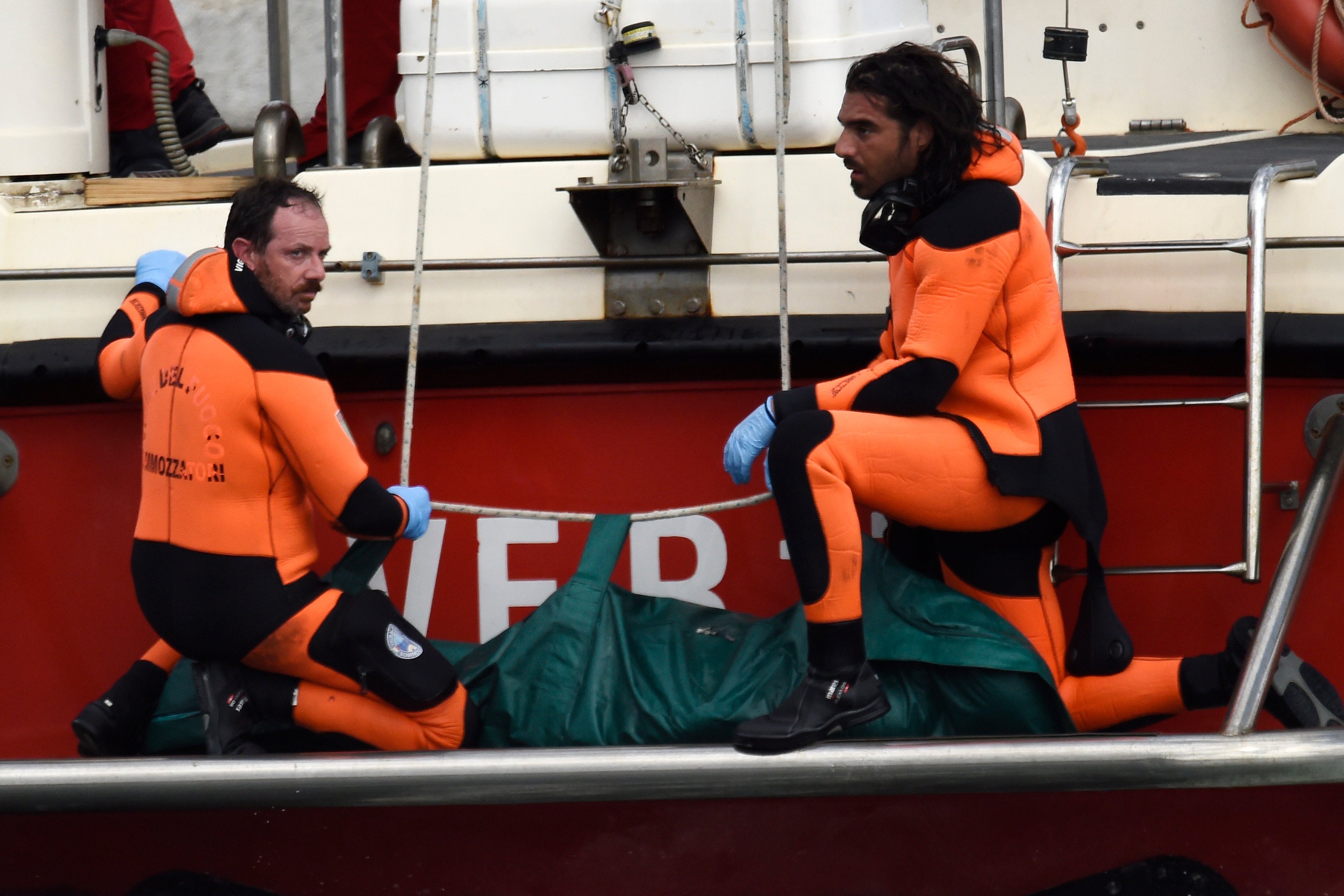 Italian Firefighters scuba divers bring ashore in a green bag the body of one of the victims of the UK flag vessel Bayesian on Wednesday. Photo: AP