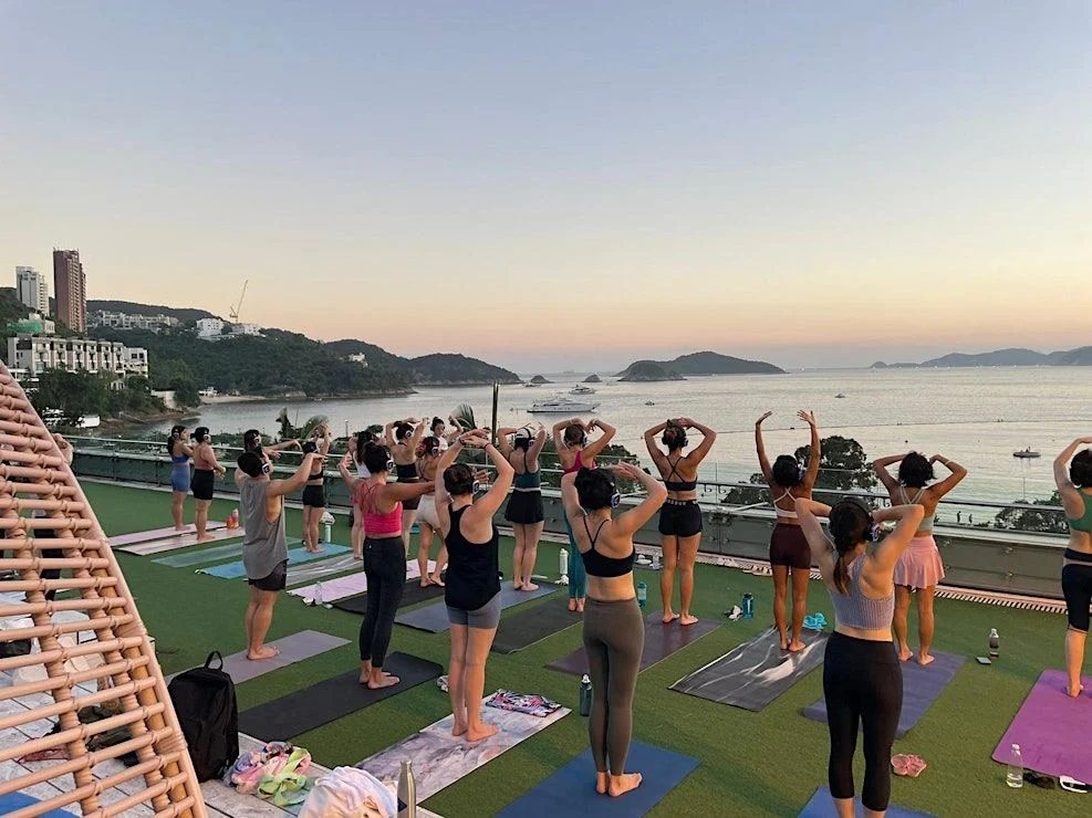 People practice yoga as the sun sets over Repulse Bay. Photo: The Yoga Room