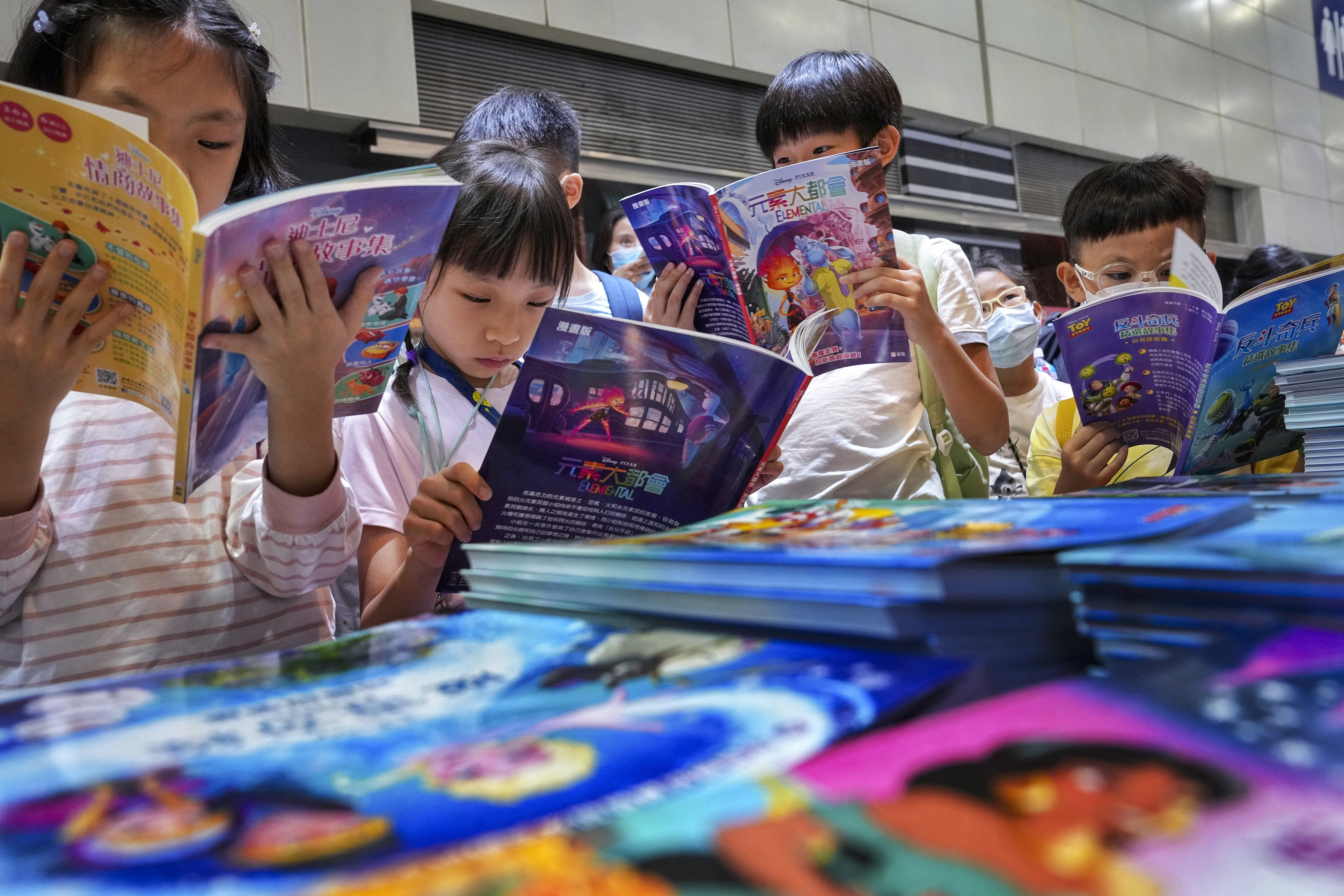 Children sample the wares at the Hong Kong Book Fair taken place at the Convention and Exhibition Centre on July 20, 2023. Photo: Elson Li