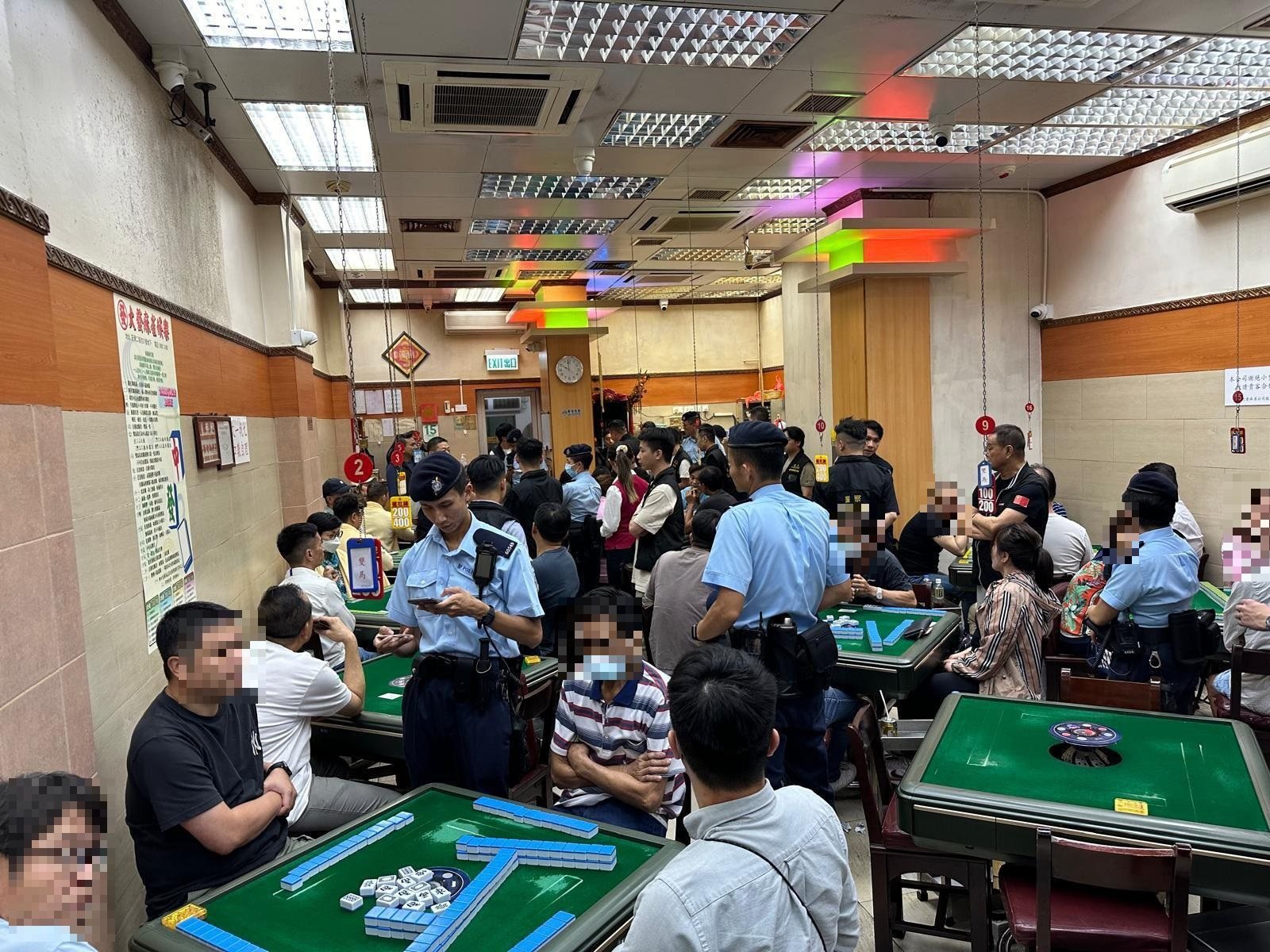 Officers check identification documents while carrying out the operation. Photo: Hong Kong police