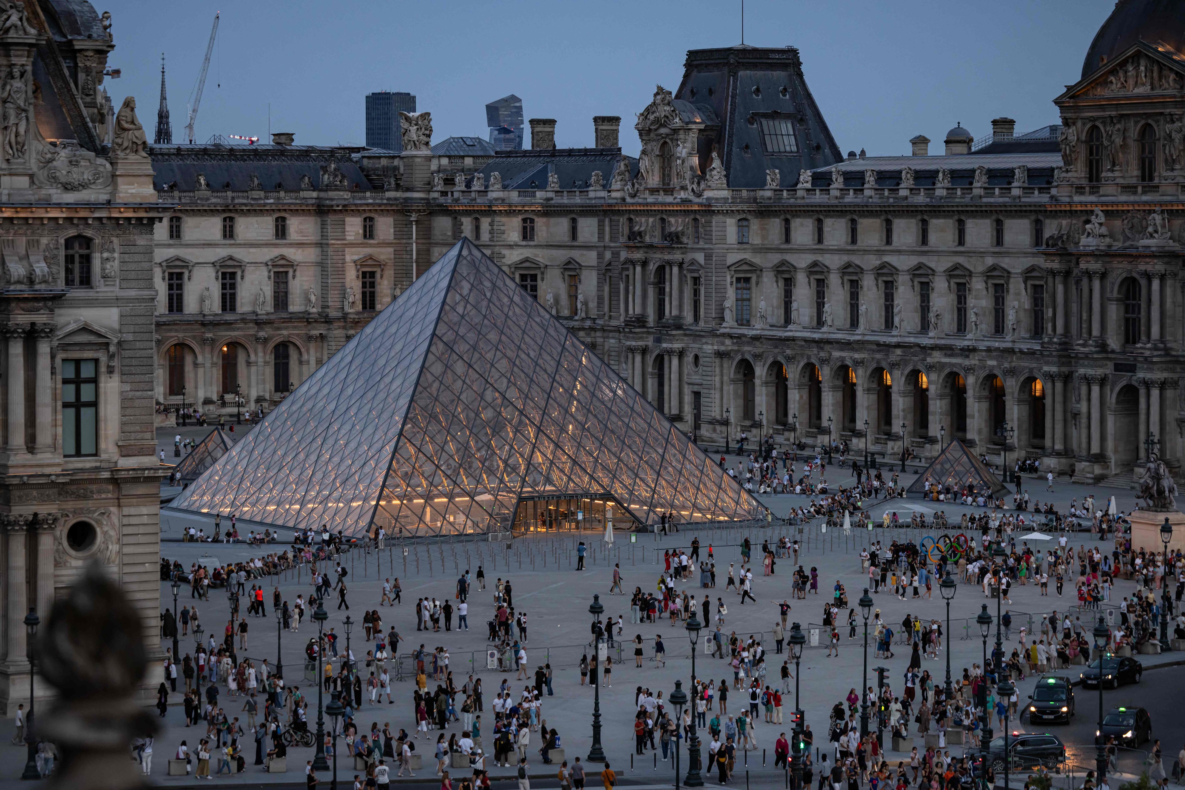 Tourists stand next to the Louvre Pyramide designed by Chinese-US architect Ieoh Ming Pei during the Paris 2024 Olympic Games in Paris. Photo: AFP