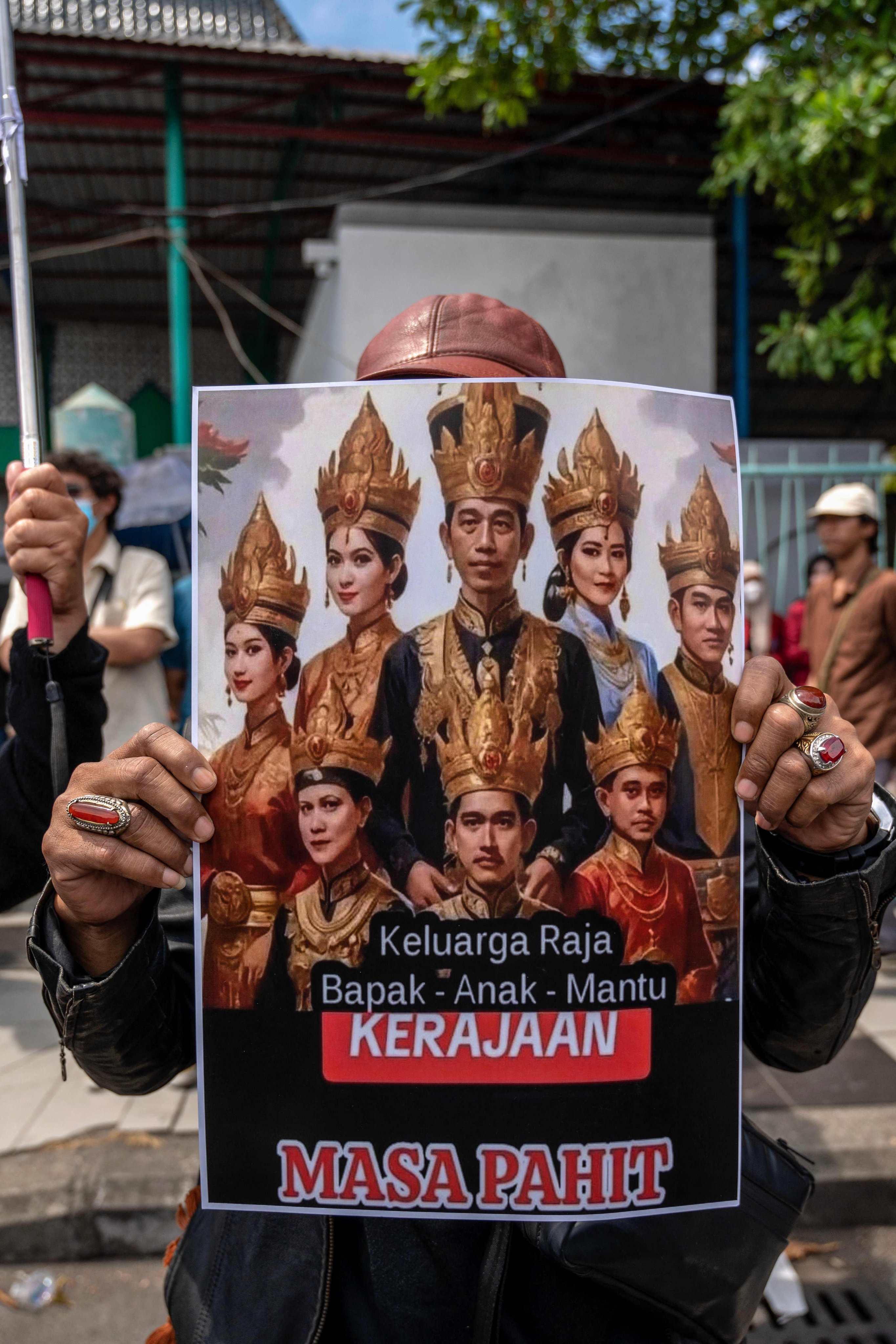 A protester in Surabaya holds a Joko Widodo family caricature during a protest against a move to overturn a constitutional court ruling that changed eligibility rules for candidates in the general election later this year. Photo: AFP