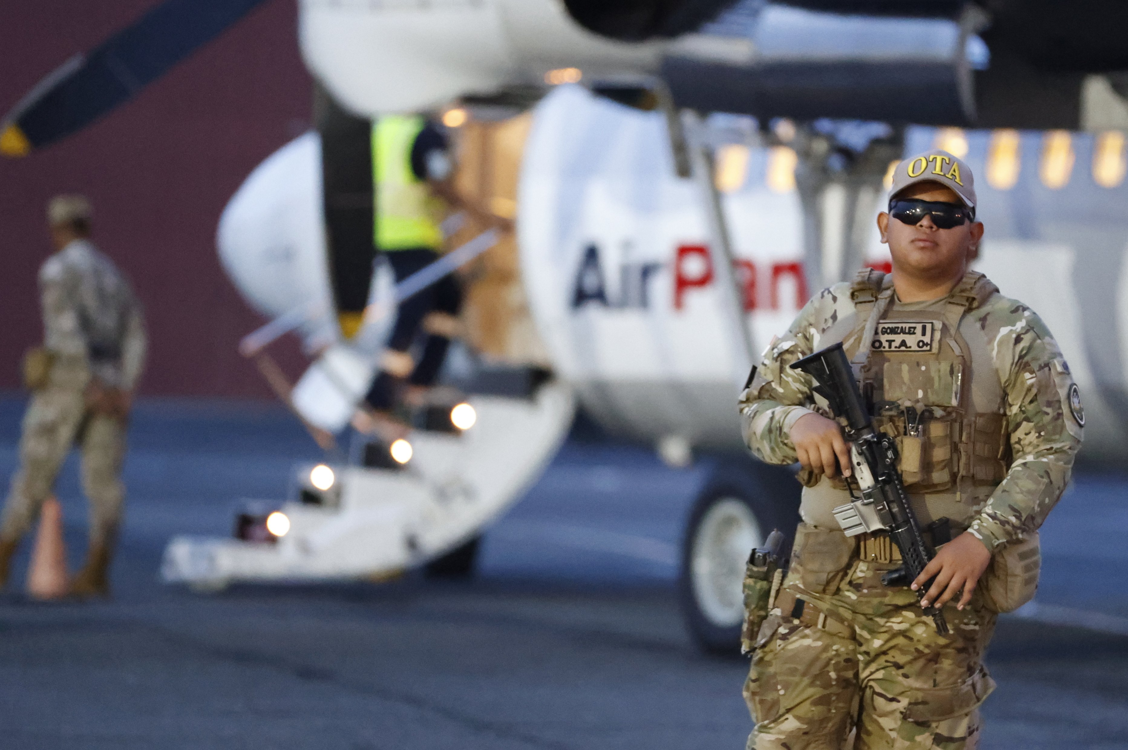 A member of Panama’s Tactical Aeronaval Operations group watches as migrants are deported to Colombia from Panama City on Tuesday. Photo: EPA-EFE