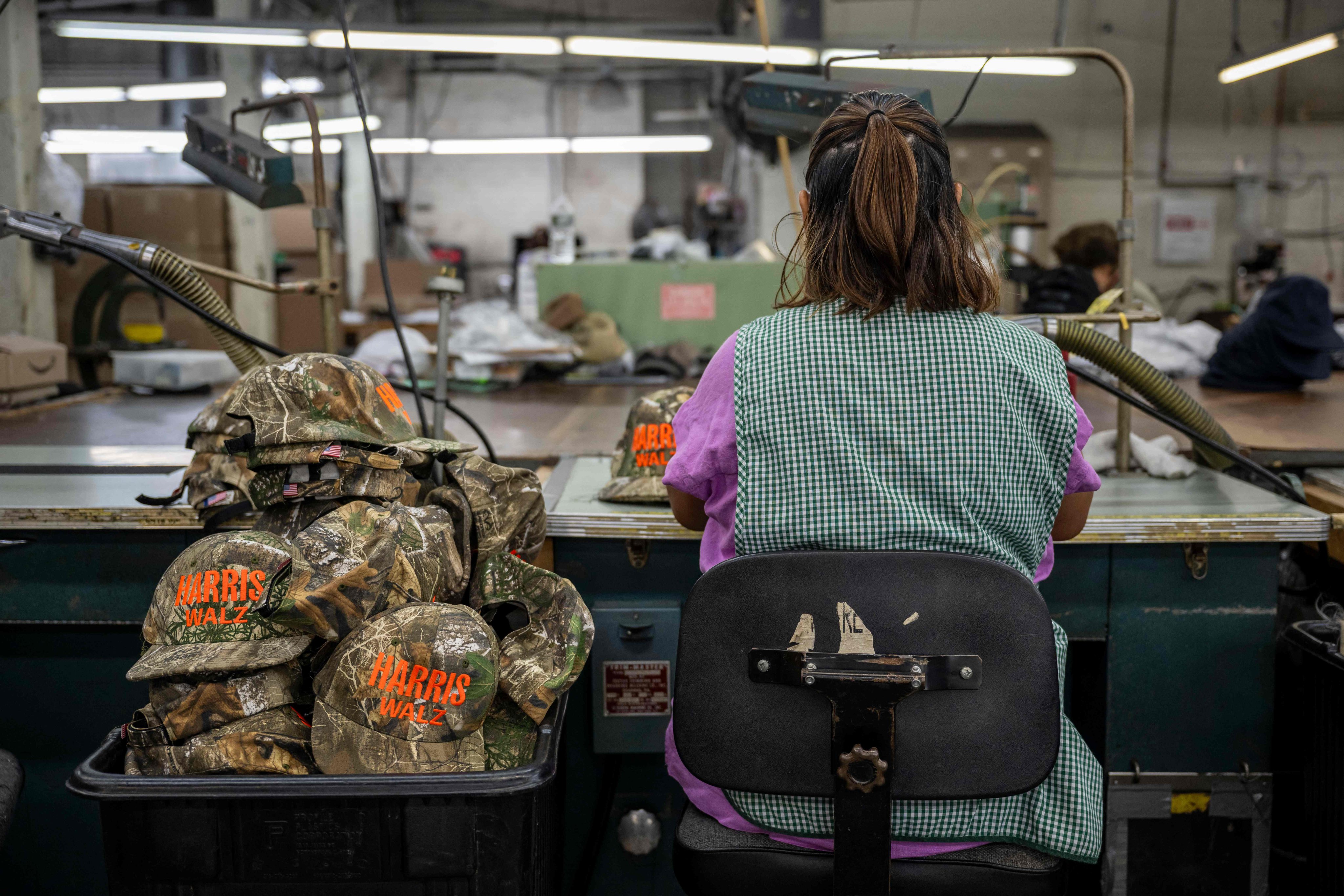 An employee works on embroidered campaign hats for US Democratic presidential candidate Kamala Harris and vice-presidential candidate Tim Walz at Unionwear in Newark, New Jersey. Photo: AFP