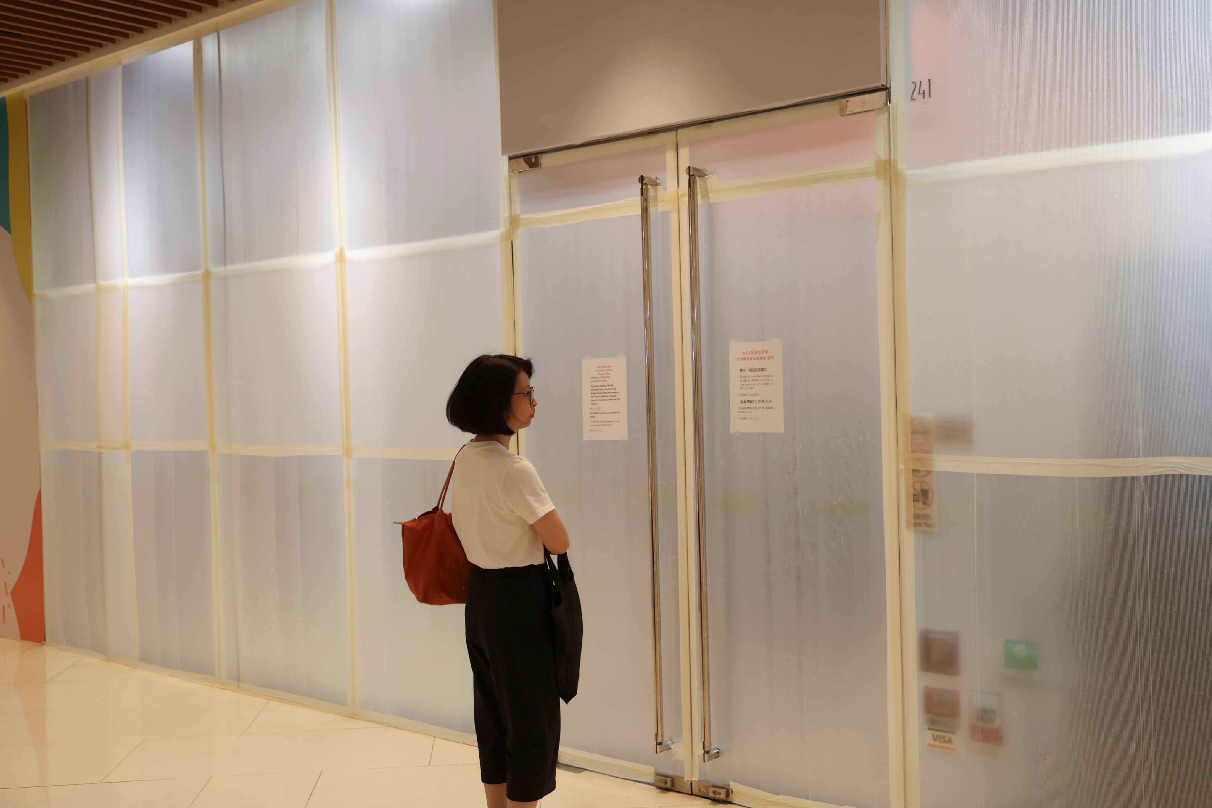 A customer looks at signs on the now-closed Tom Lee Music store in Kennedy Town. Photo: Dickson Lee