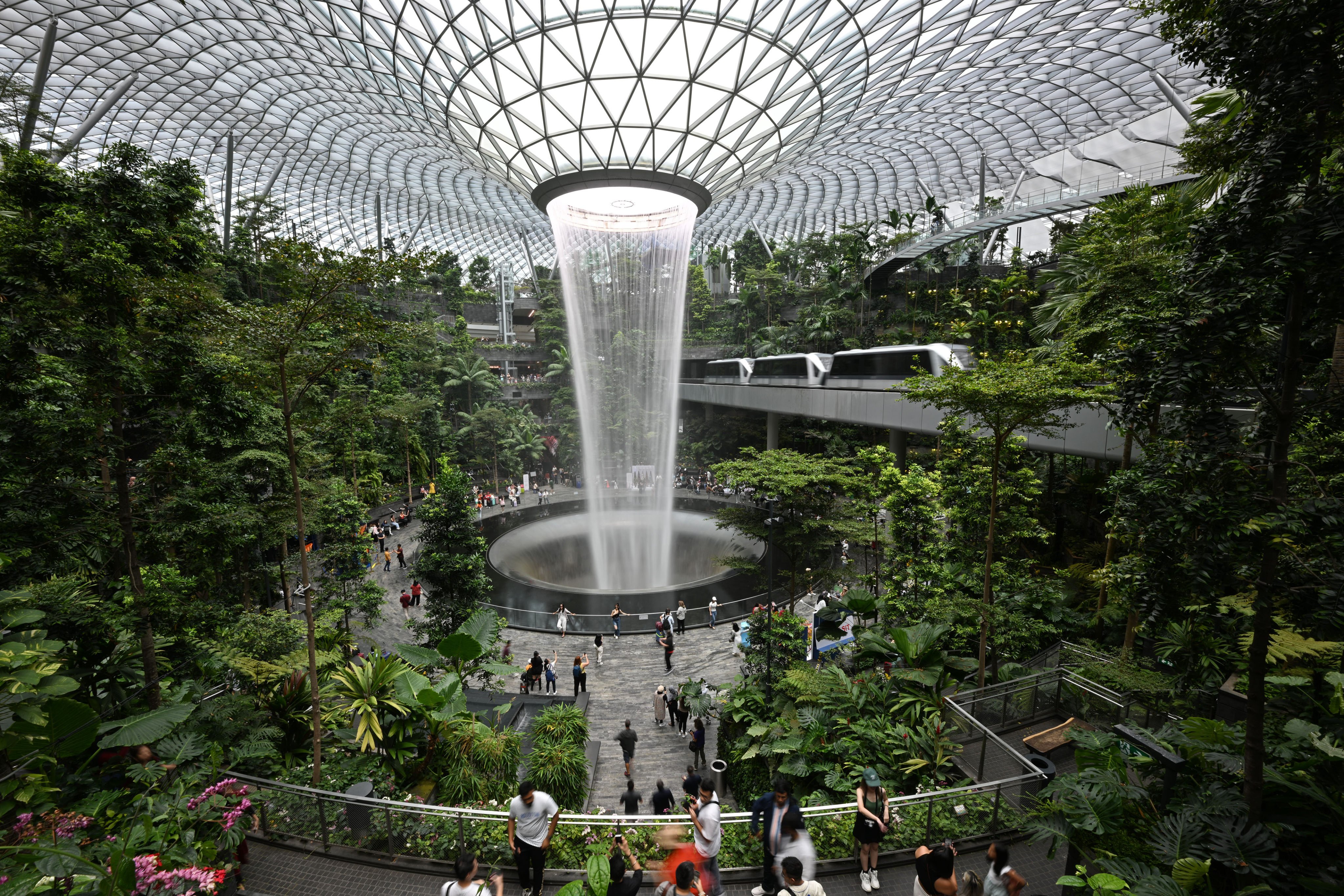 Visitors walk through the Jewel as a Skytrain shuttles passengers between terminals at Changi Airport in Singapore. Photo: Xinhua