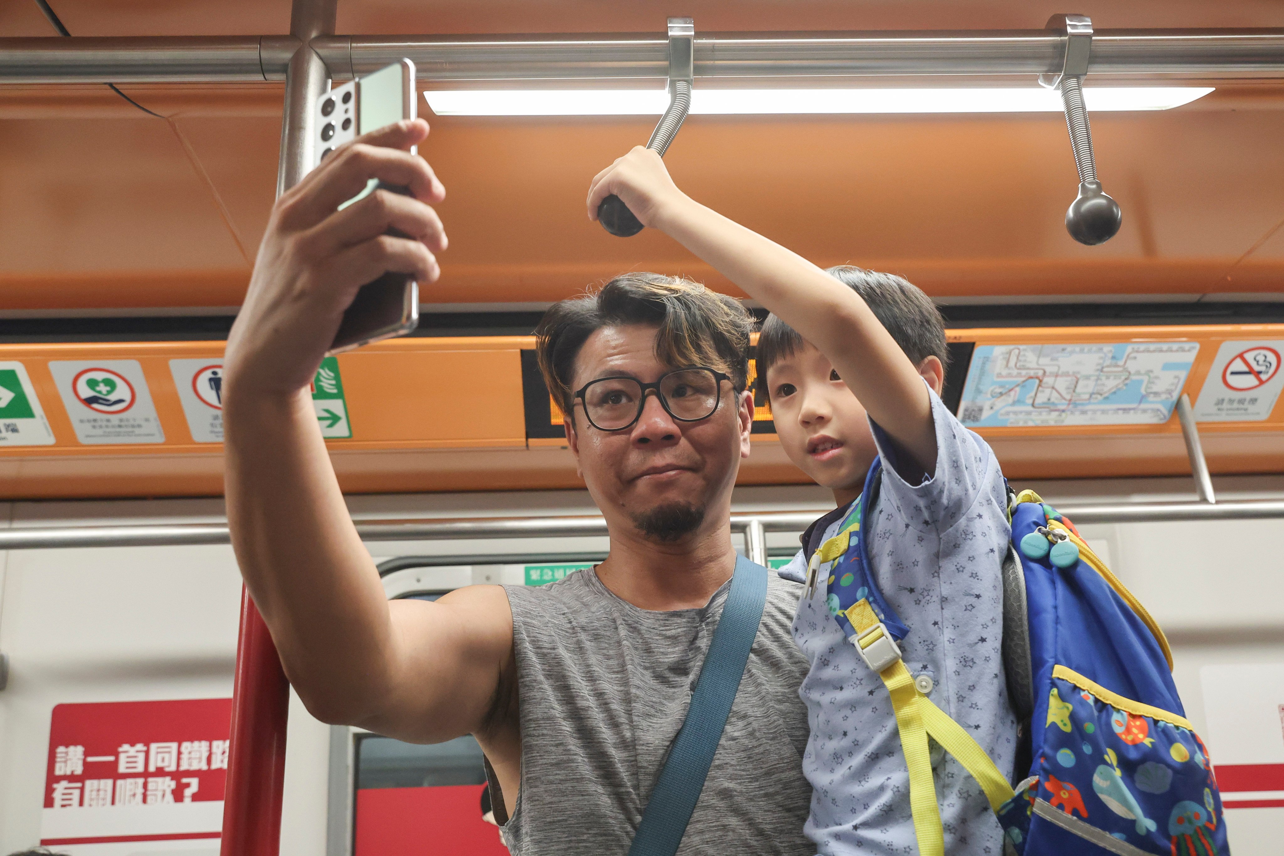 A father introduces his son to old-style hand straps in one of the carriages. Photo: Edmond So