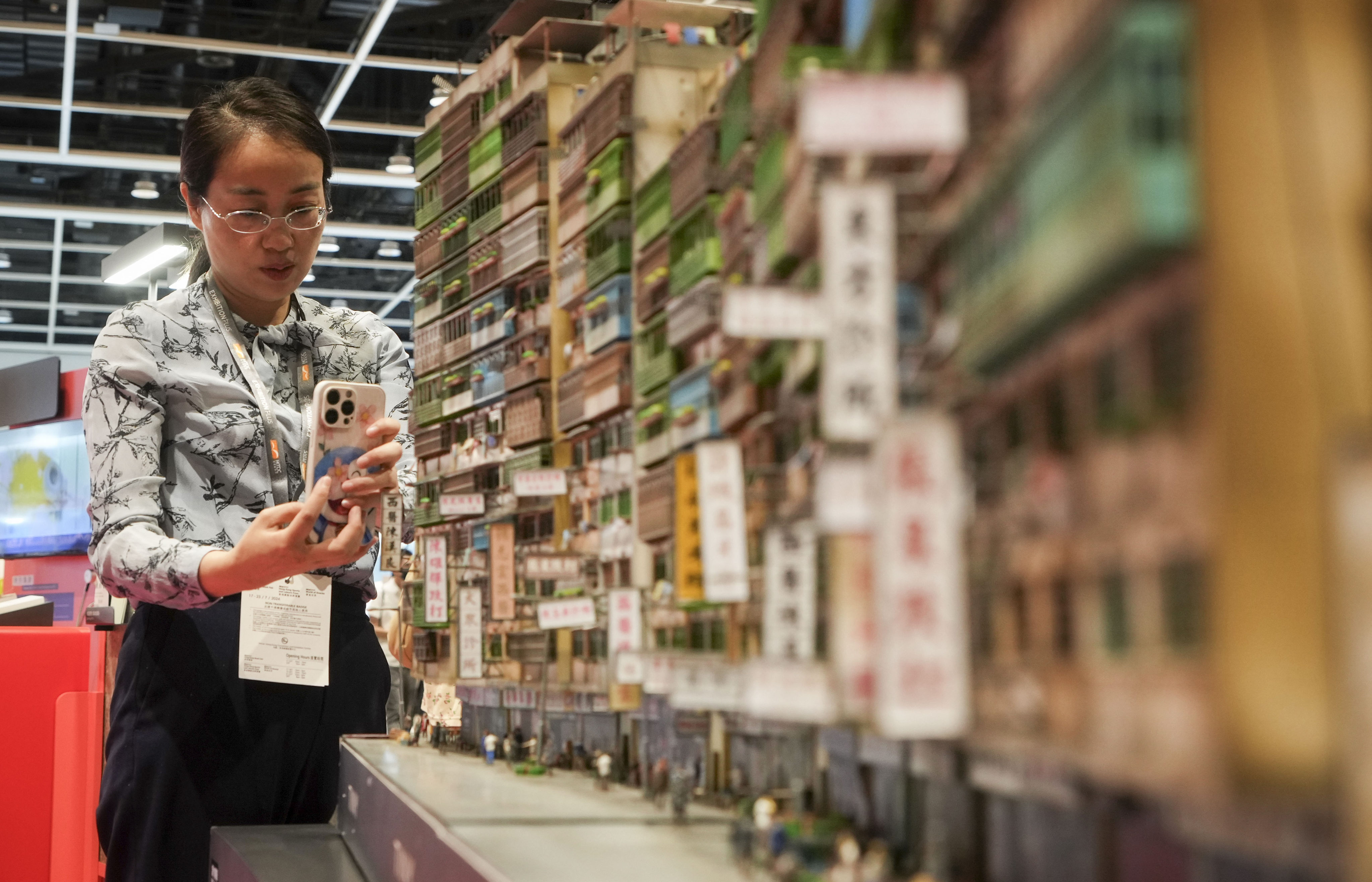 A woman takes a  photo of a diorama of Kowloon Walled City is showcased at an exhibition at the Hong Kong Book Fair on July 14. An expanded gallery featuring the city’s urban development could be a tourist attraction. Photo: Elson Li