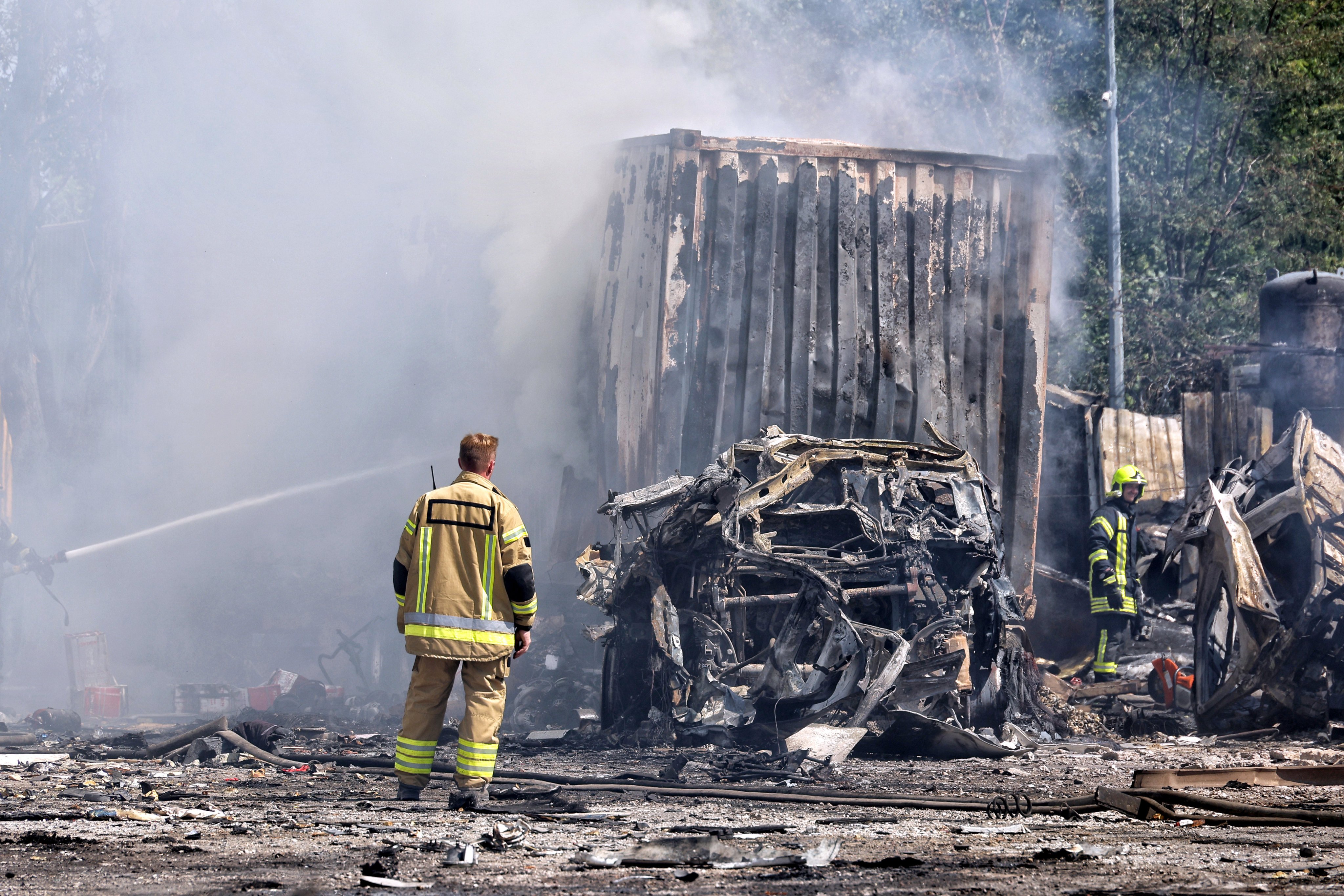 Rescuers stand by the cars of a transport company destroyed by a massive Russian missile and drone attack on Monday. Photo: Ukrinform / dpa