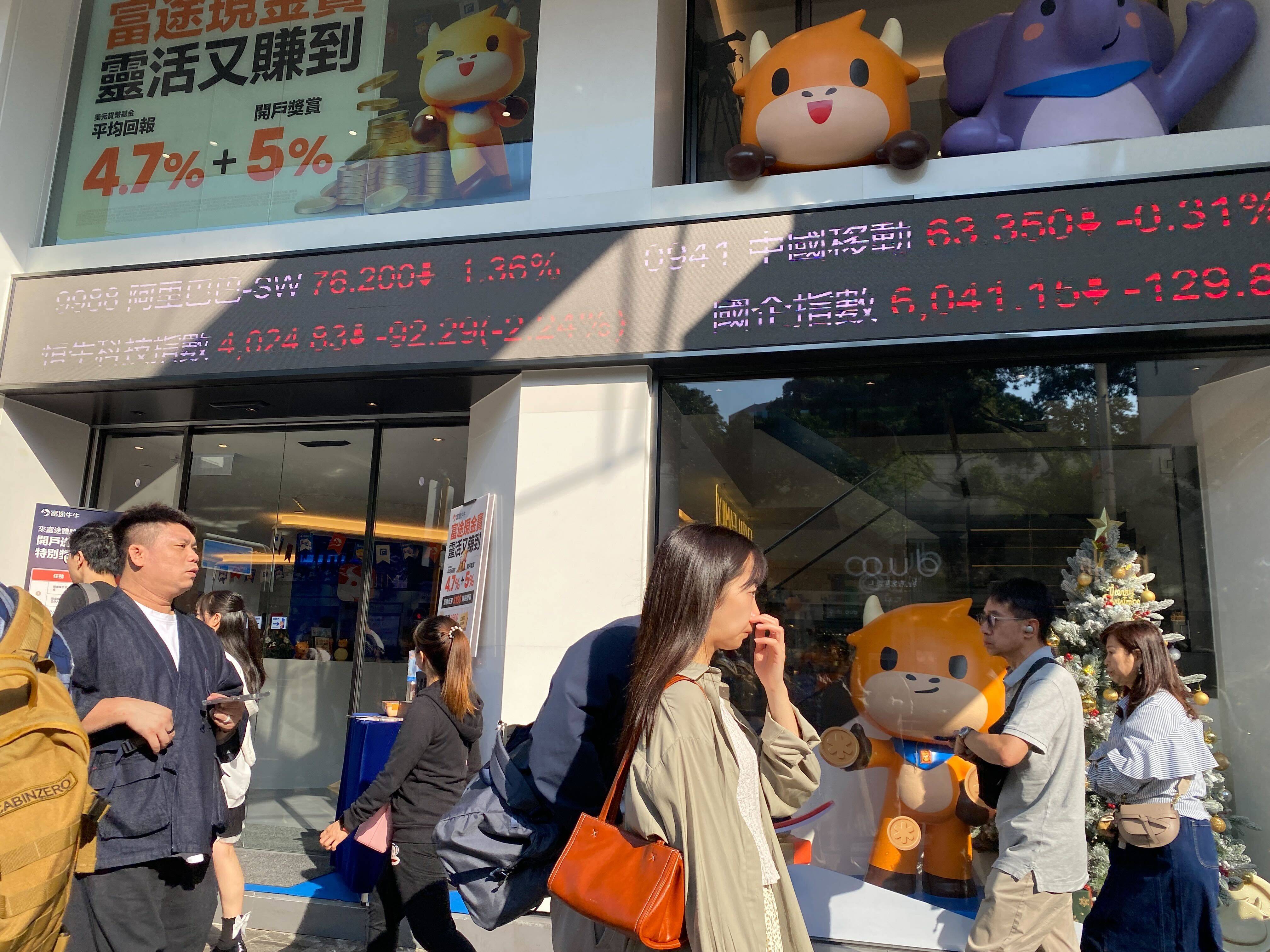 People walking outside a building with running stock tickers in Tsim Sha Tsui, Hong Kong in November 2023. Photo: Li Jiaxing