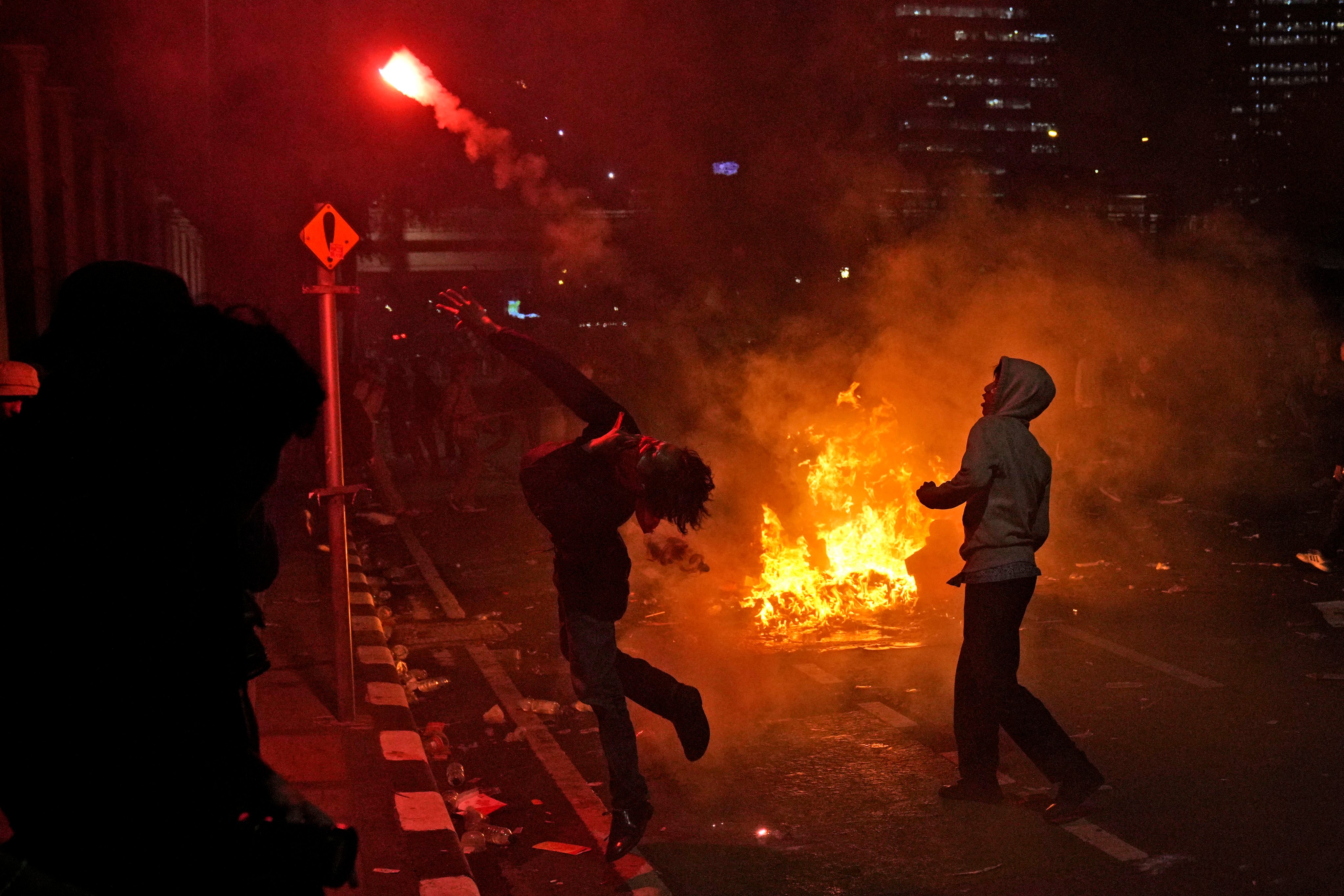 A student protester throws a flare at riot police during a rally on Thursday last week against controversial changes to Indonesia’s election laws. Photo: AP 