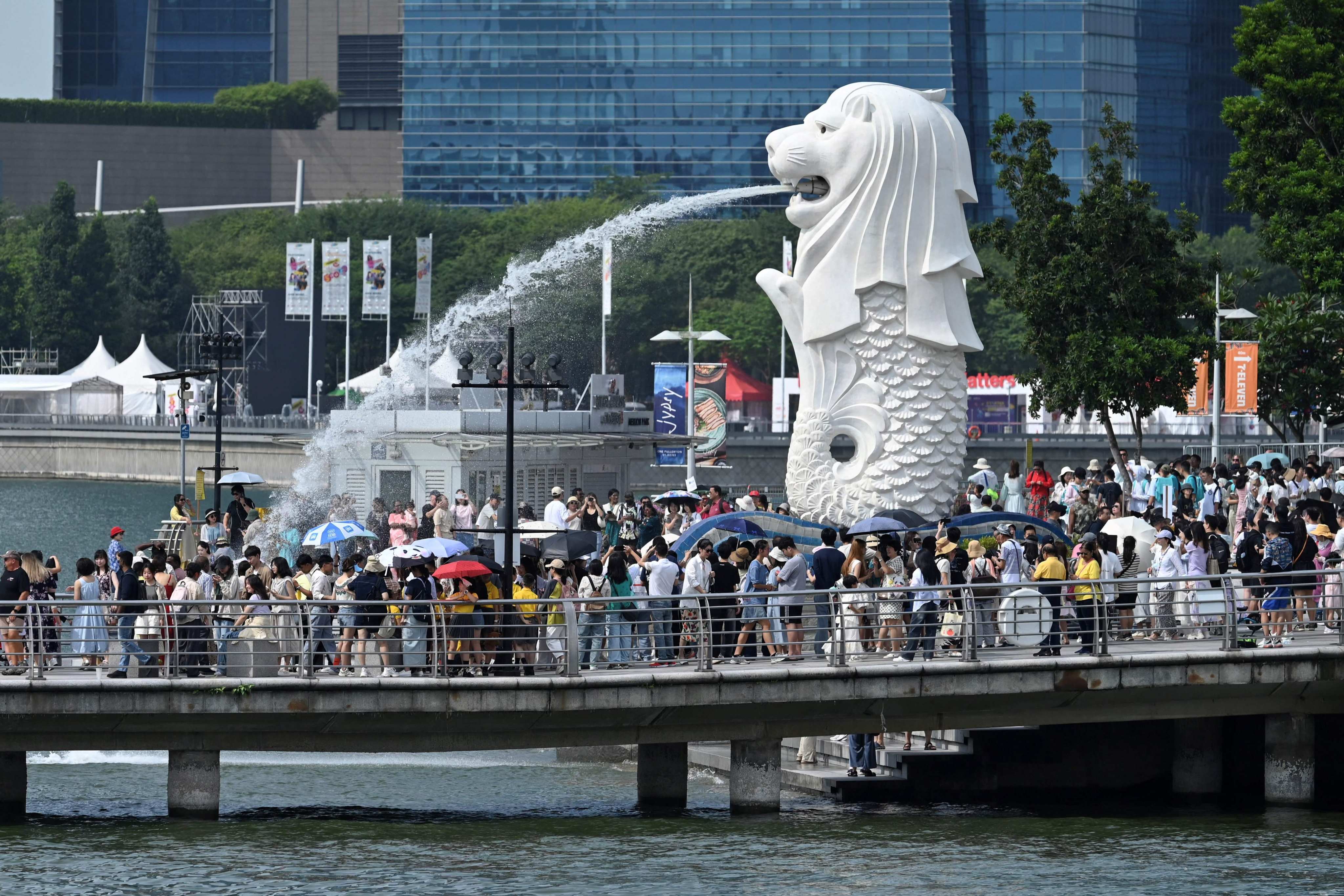 People gather next to the Merlion statue at the Marina Bay Waterfront Promenade in Singapore on August 7, 2024. Photo: AFP